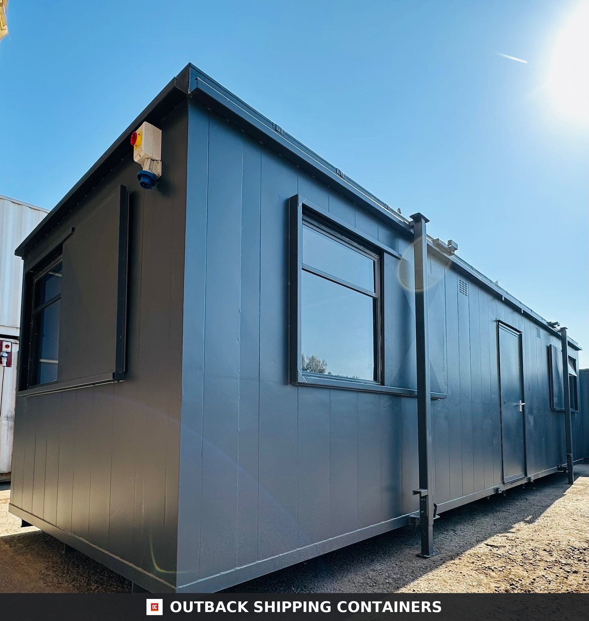 32x10ft Cabin for Sale — Rear Exterior View | Outback Shipping Containers 2 3 Side profile of a dark gray 32ft anti-vandal portable cabin with steel security shutters over large windows