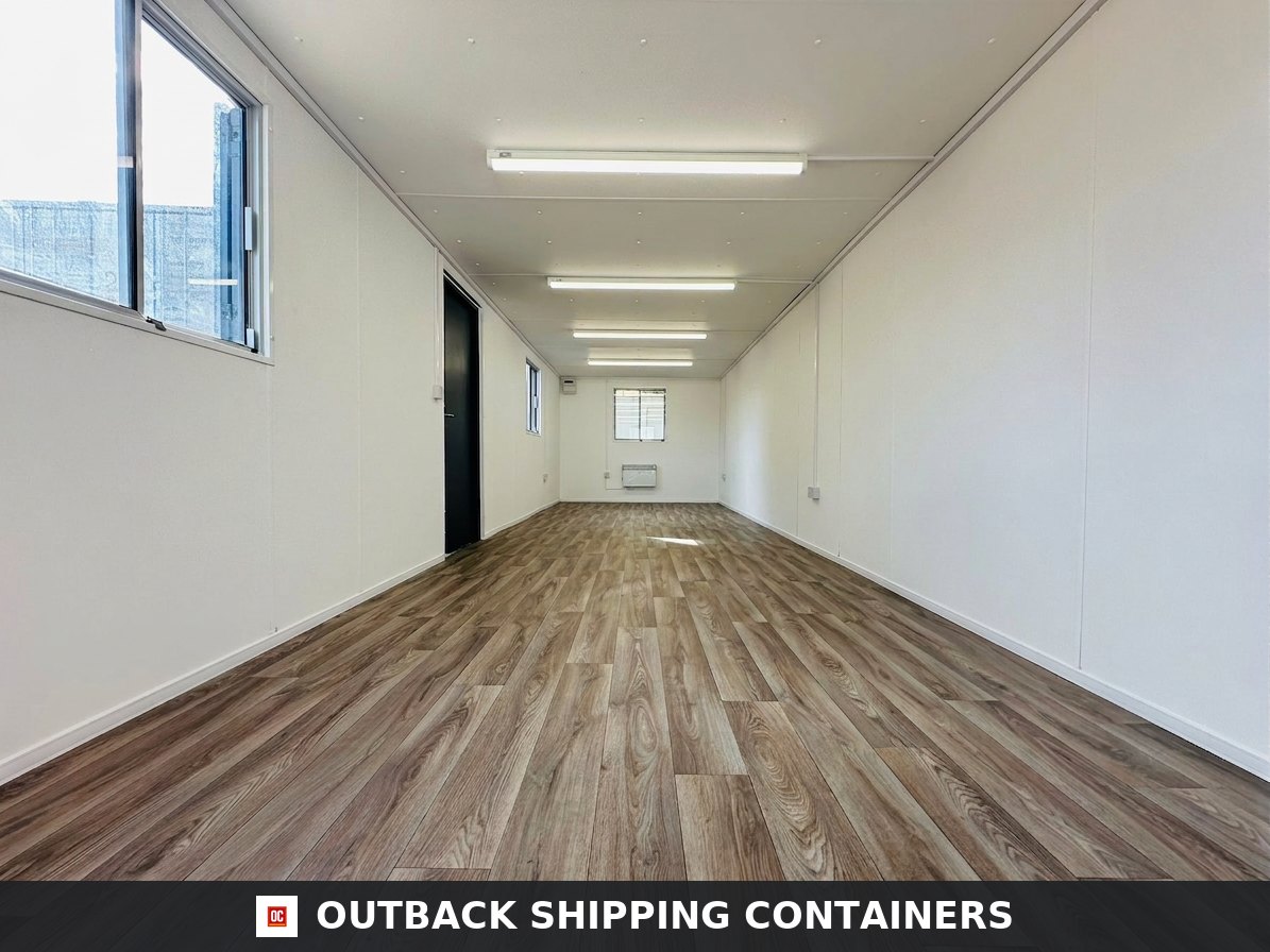 32ft Cabin for Sale — Side Profile View | Outback Shipping Containers 2 3 Interior view of a refurbished 32ft office container with wood-style flooring and white paneled walls