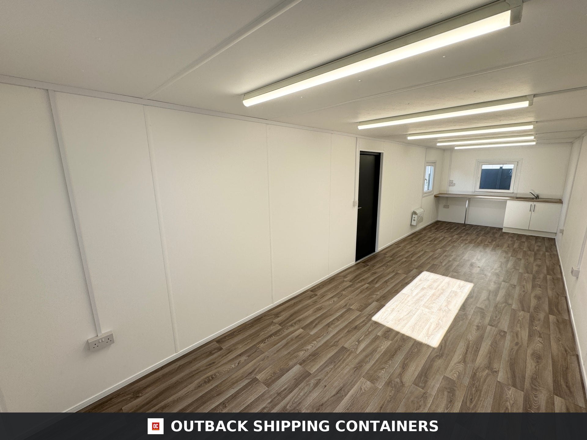 32x10ft Cabin for Sale — Corner Casting and Frame Detail | Outback Shipping Containers Exterior view of a dark grey 32x10 portable cabin with corrugated steel walls and shuttered window