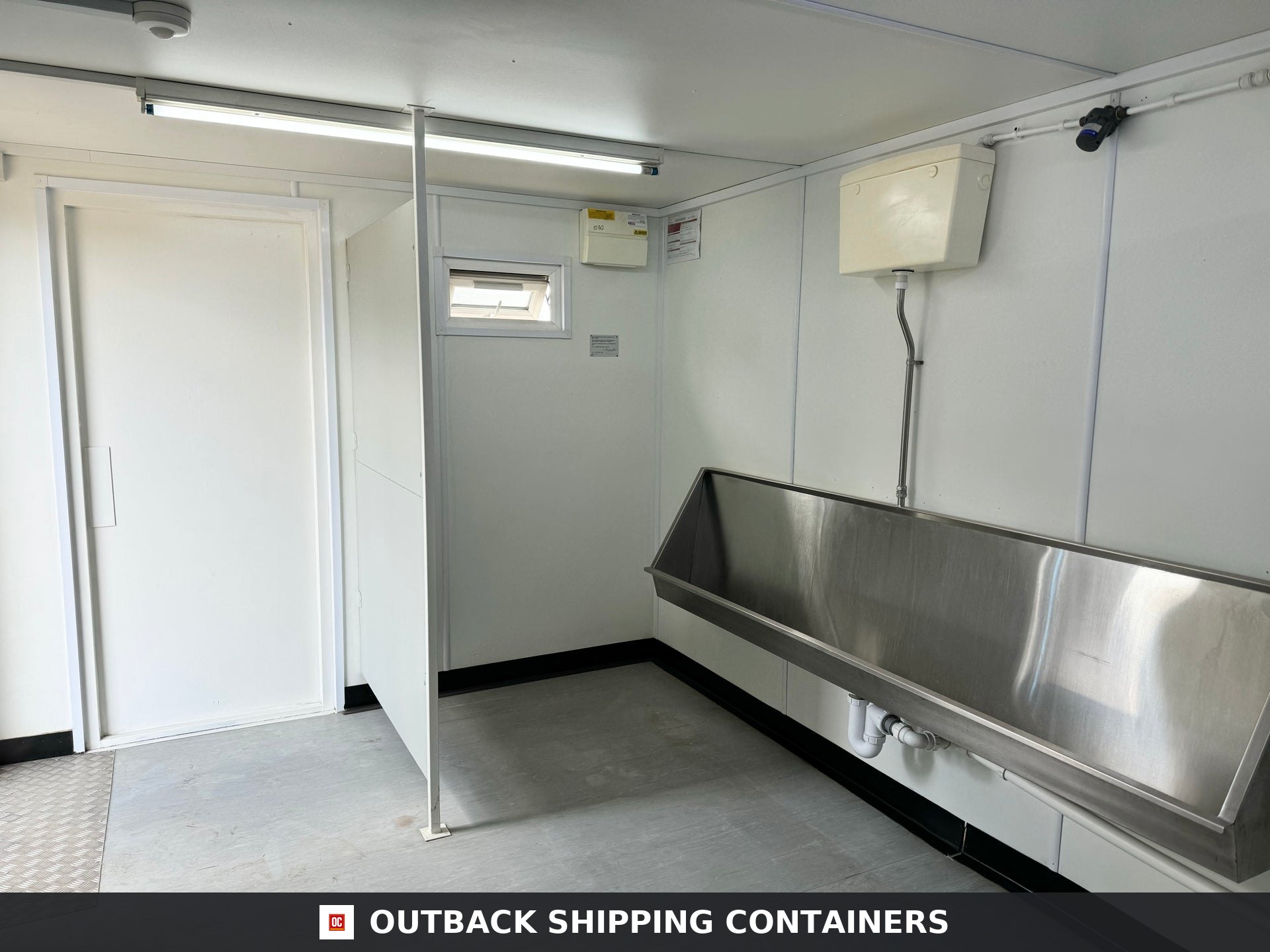 21x8ft for Sale — Rear Exterior View | Outback Shipping Containers Interior view of refurbished canteen unit showing white toilet stalls and a row of ceramic sinks with a water heater