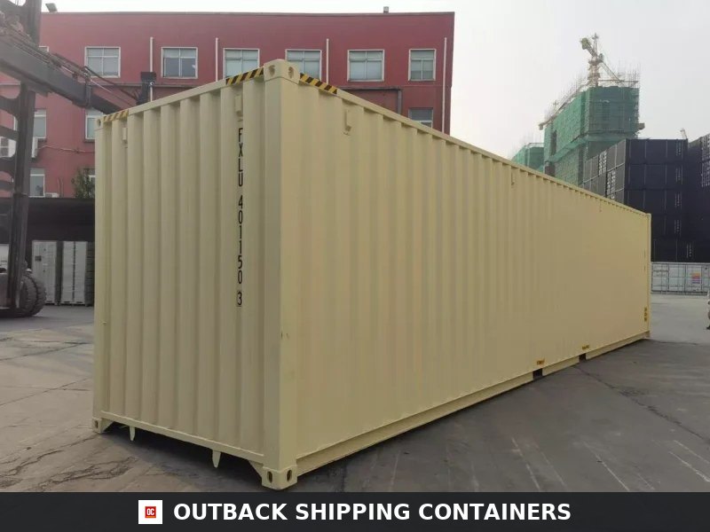 Tan 40ft High Cube open side shipping container with closed doors parked on an asphalt yard near a red building