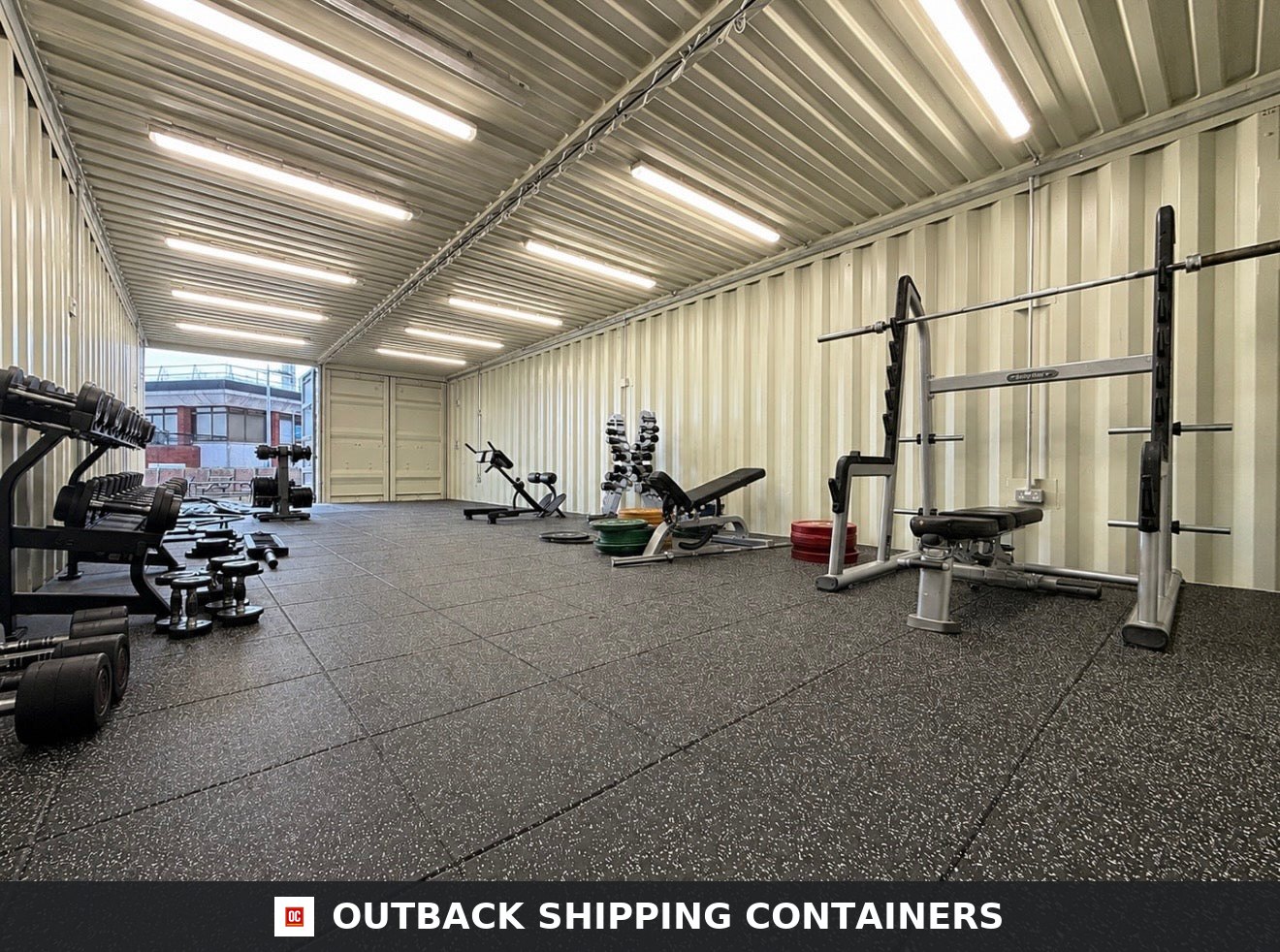 40x16ft for Sale — Side Profile View | Outback Shipping Containers Interior of a 40ft custom shipping container gym with rubber flooring, squat rack, and dumbbell rows