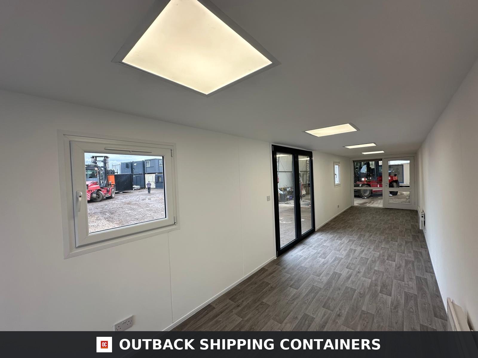 40ft container office interior with white walls, wood-look flooring, square LED lights, and double glass doors