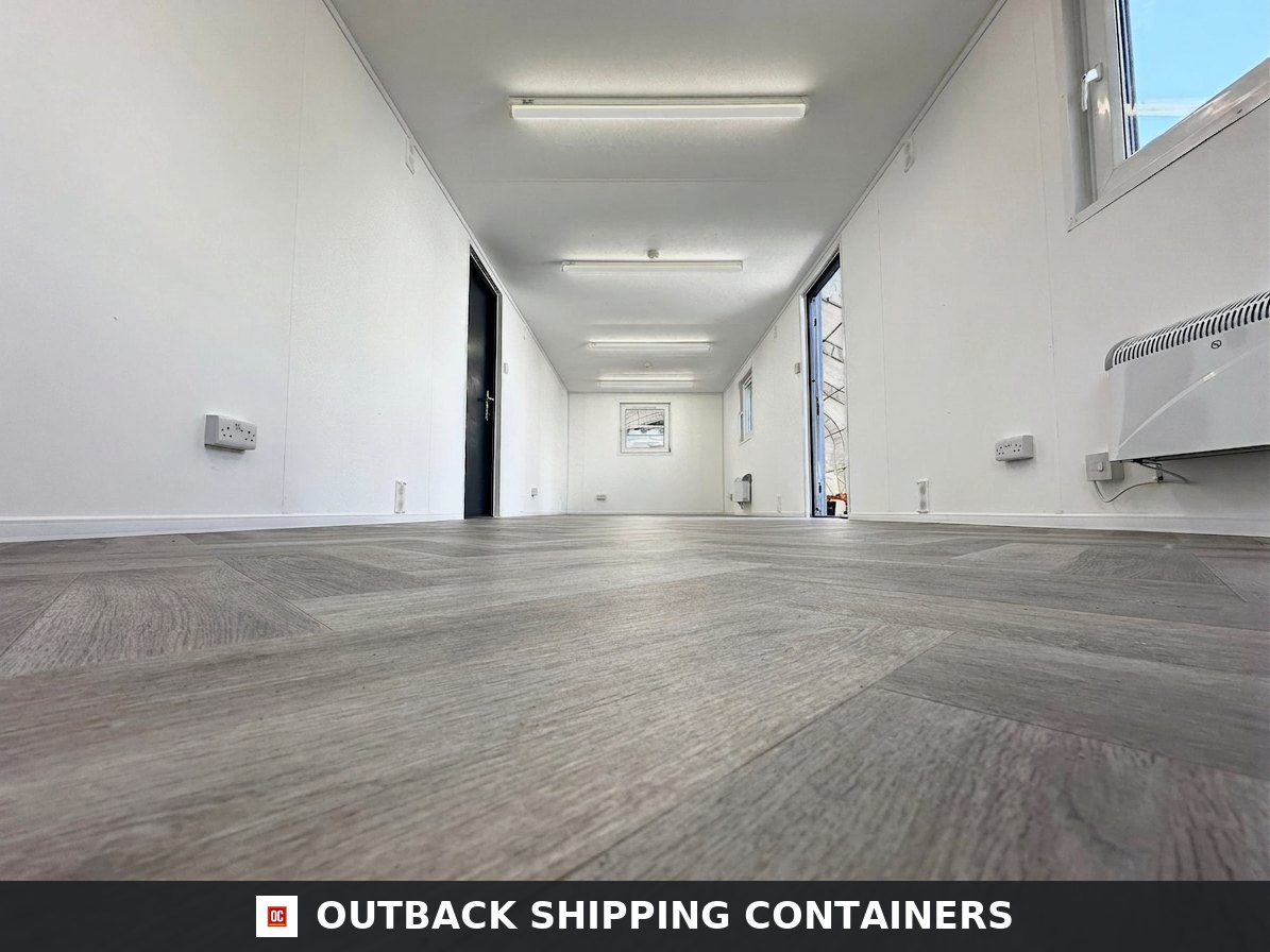 32x10ft Cabin for Sale — Side Profile View | Outback Shipping Containers 2 Interior of a refurbished 32x10ft portable office cabin with white walls, wood-style flooring, and LED lighting