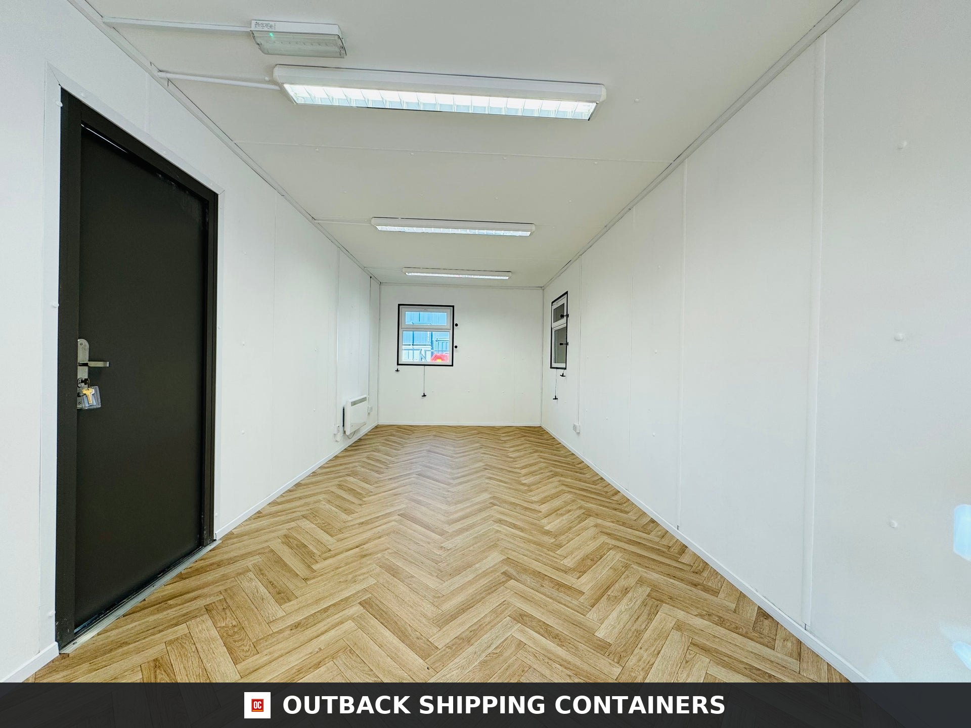 32ft Cabin for Sale — Three-Quarter Angle View | Outback Shipping Containers 2 Refurbished 32ft anti-vandal portable cabin in dark gray with windows and secure door outdoors