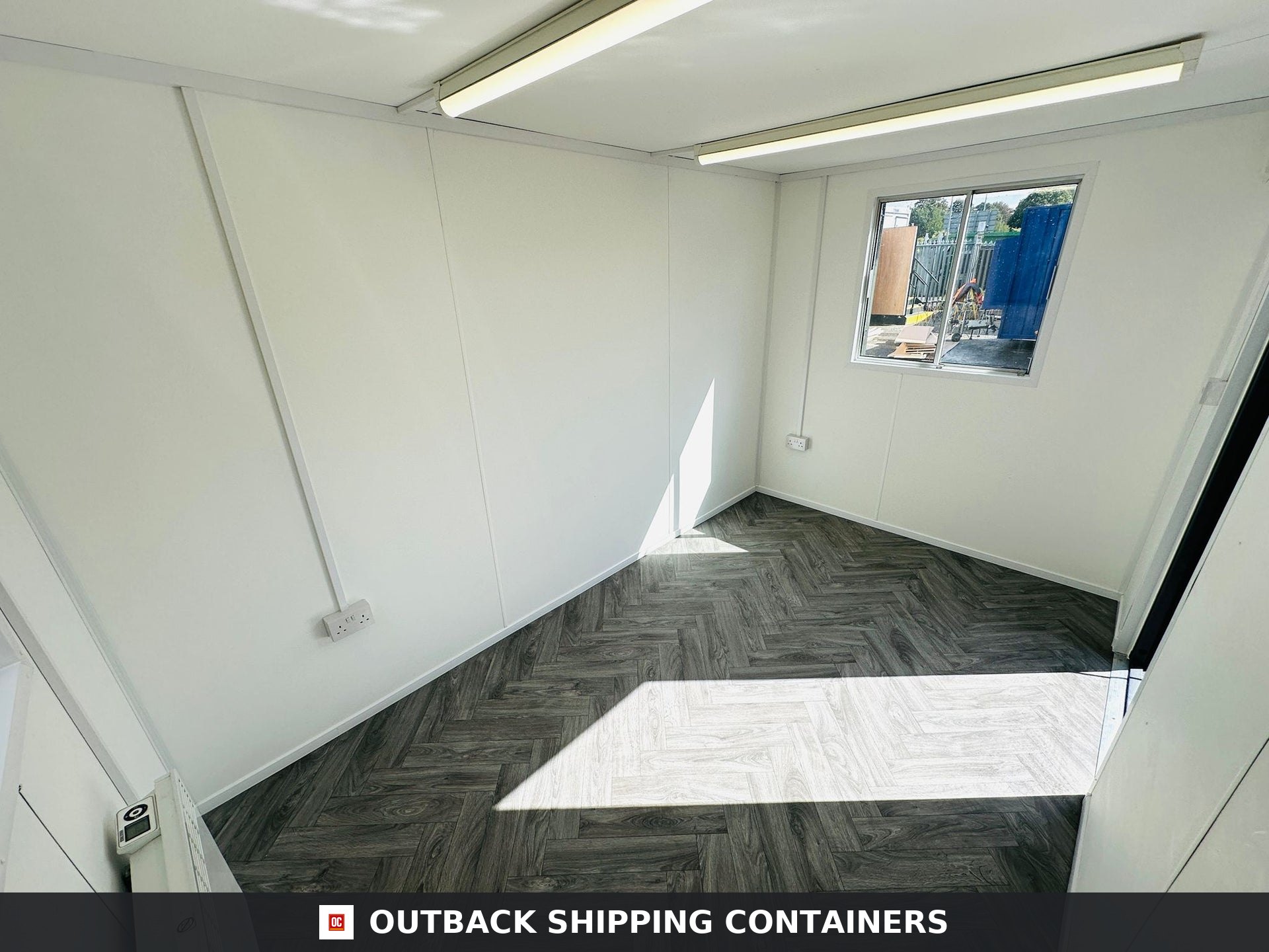 12x8 ft 12x8FT for Sale — Three-Quarter Angle View | Outback Shipping Containers Grey 12x8 anti-vandal portable office container with open steel security shutters and a glass window