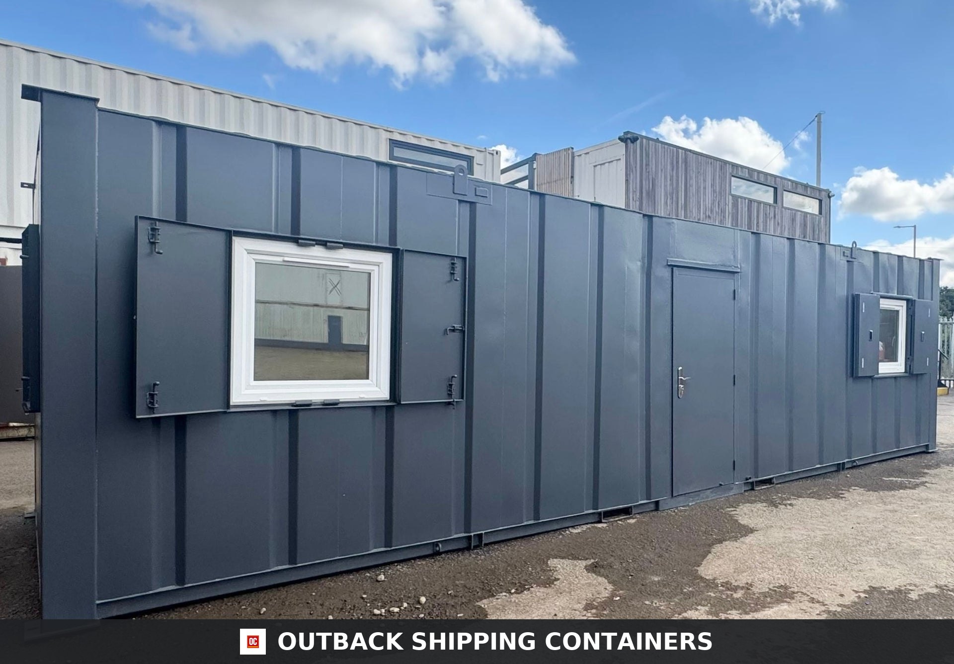 32ft Cabin for Sale — Interior View | Outback Shipping Containers Refurbished 32ft anti-vandal cabin in dark gray with open steel shutters and a side entrance door