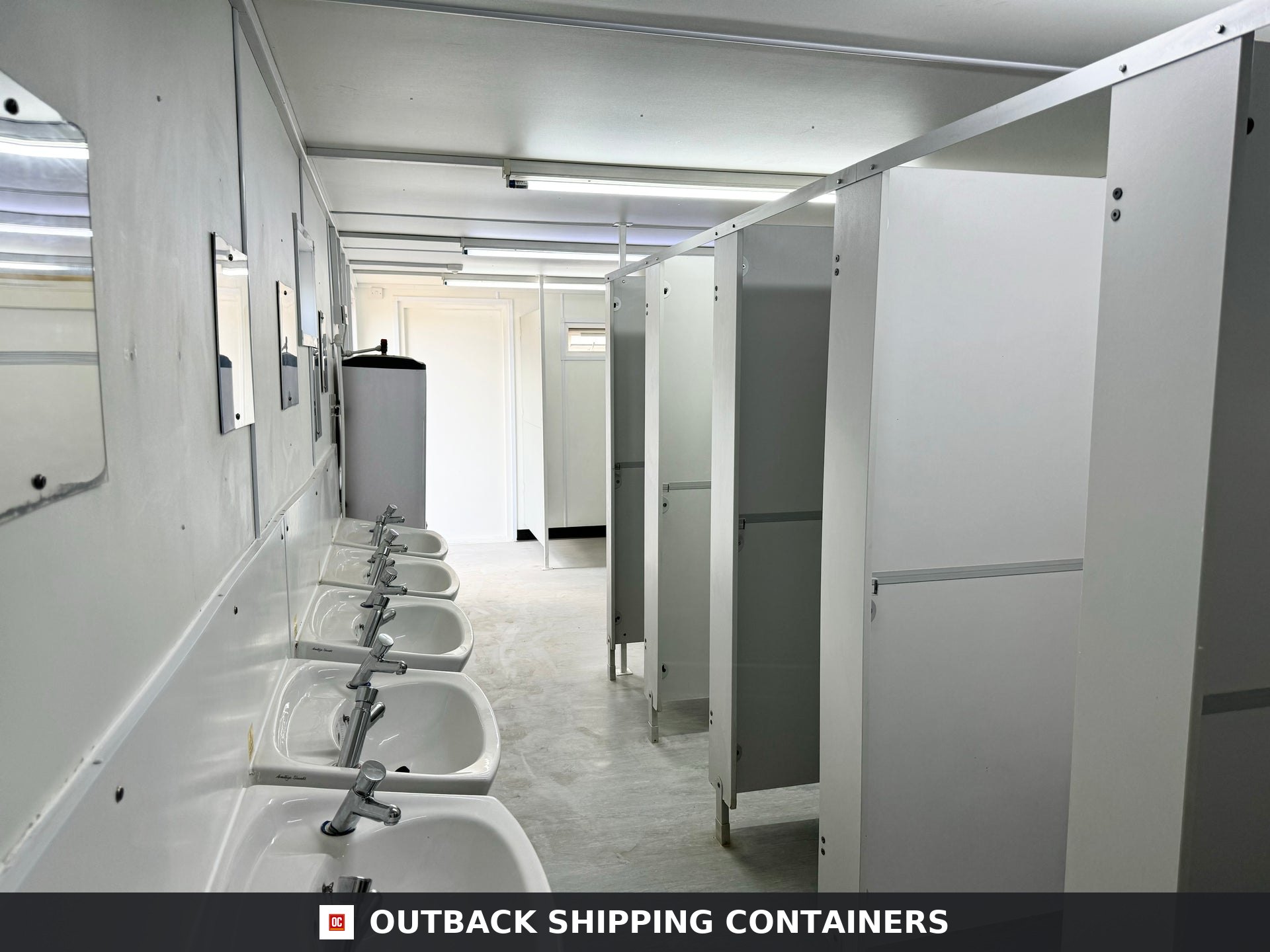 21x8ft for Sale — Three-Quarter Angle View | Outback Shipping Containers Interior view of a refurbished site accommodation restroom featuring urinal, toilet cubicles, and a water heater tank