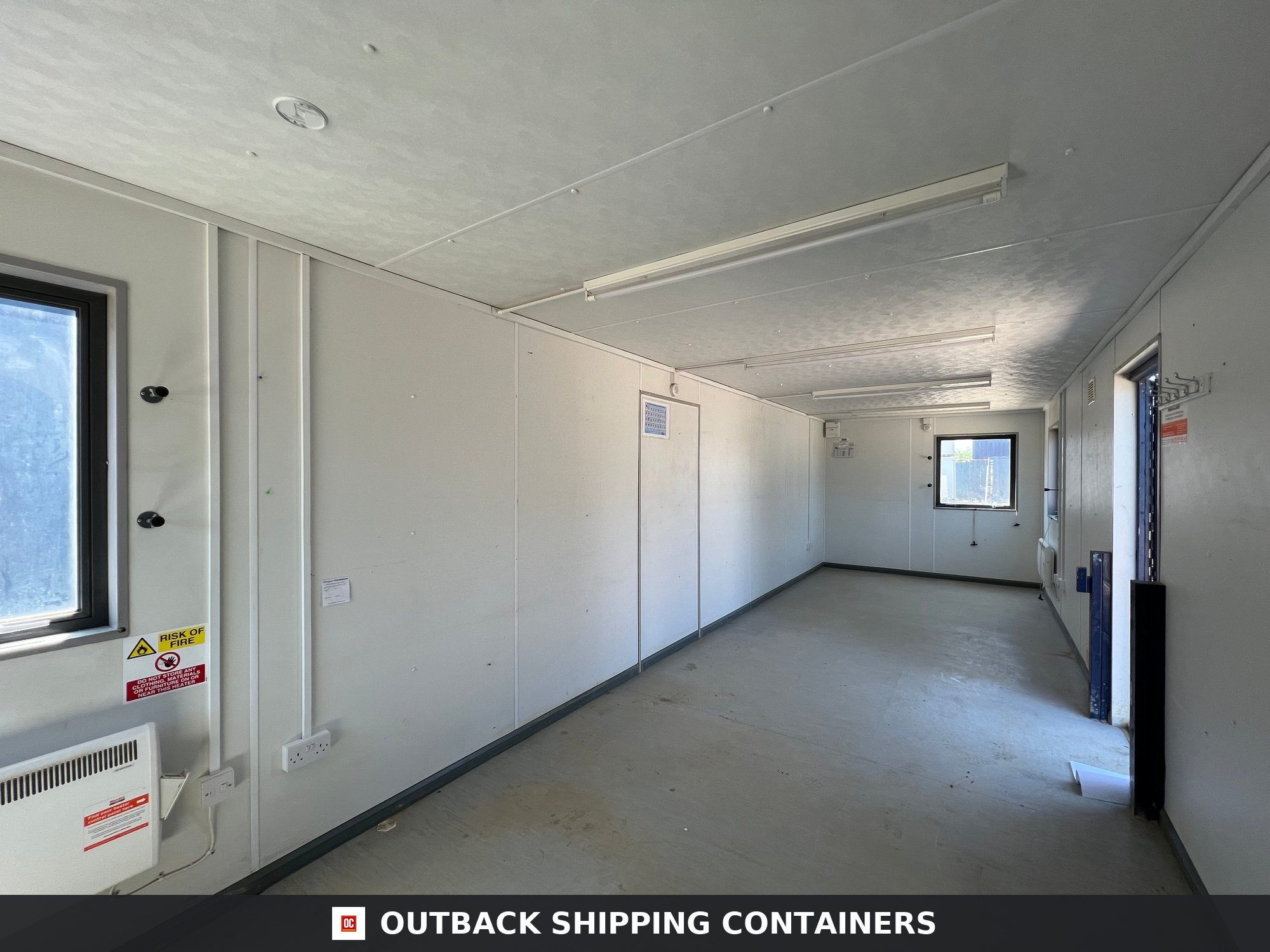 24x9 ft 24X9FT for Sale — Side Profile View | Outback Shipping Containers Interior view of an empty 24x9 ft open plan office cabin with white walls and overhead LED fluorescent lighting