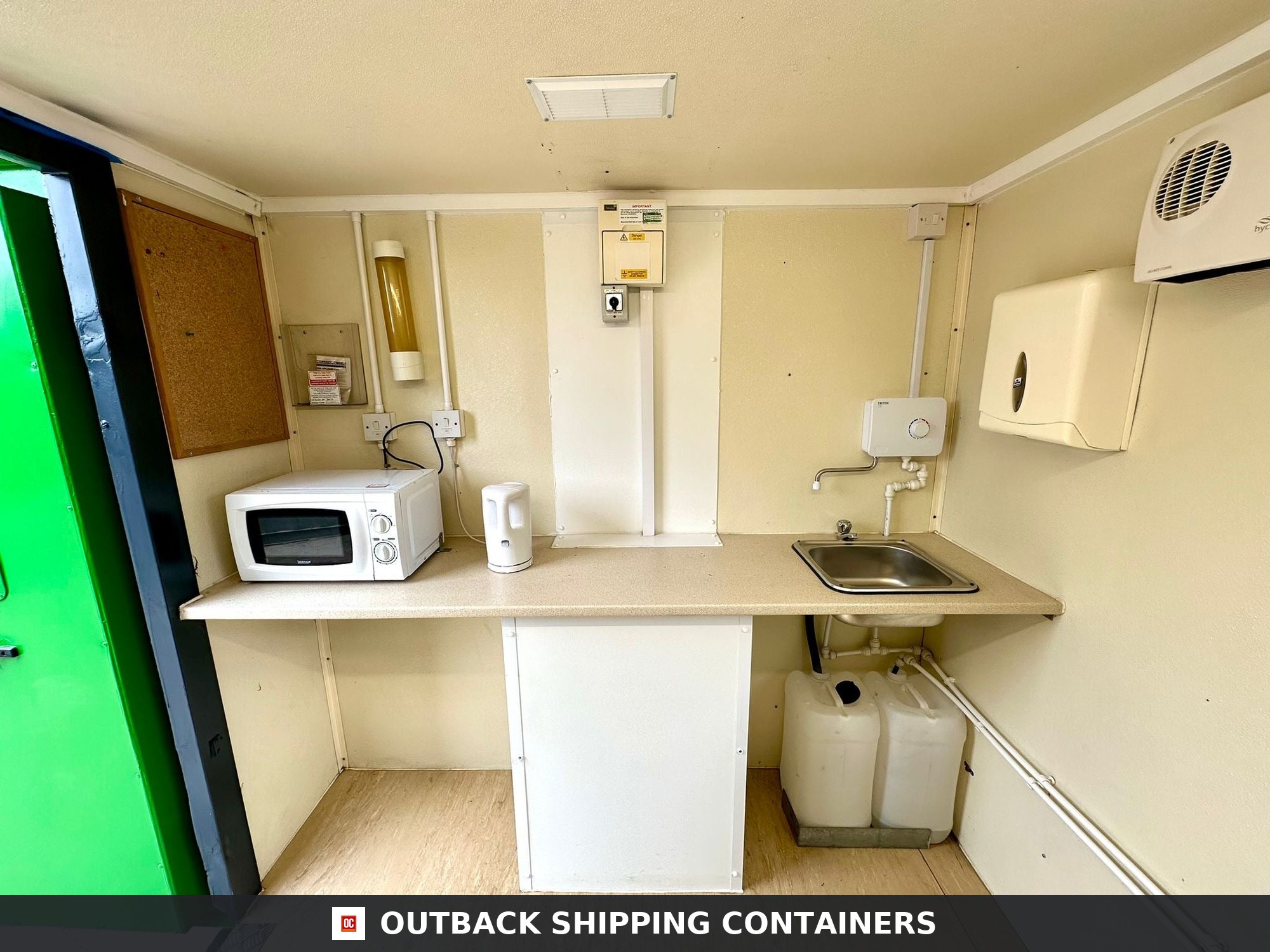 Groundhog Towable Mobile Welfare | Towable Canteen + Toilet & Drying — Door and Entry Detail Interior view of a refurbished Groundhog GP 360 welfare unit featuring a kitchenette with microwave and sink