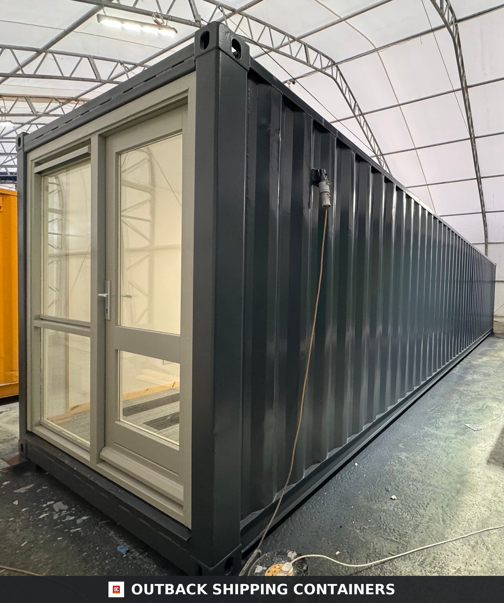 40ft converted shipping container office with charcoal grey exterior and glass pedestrian door entrance