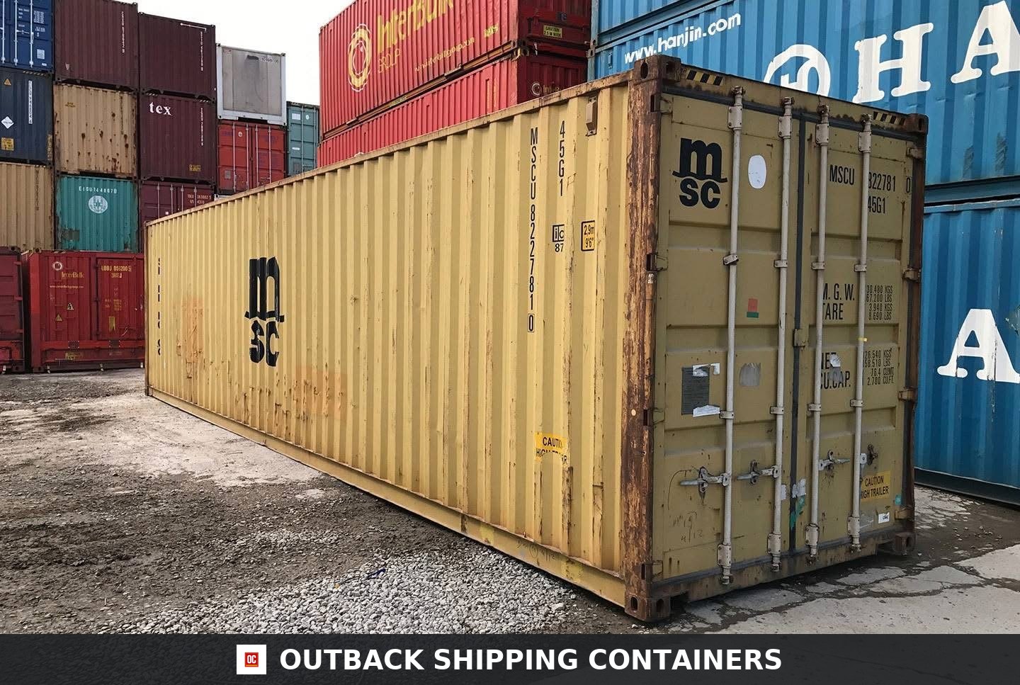 40ft storage container used condition in tan color with barn doors and steel locking bars on a gravel lot
