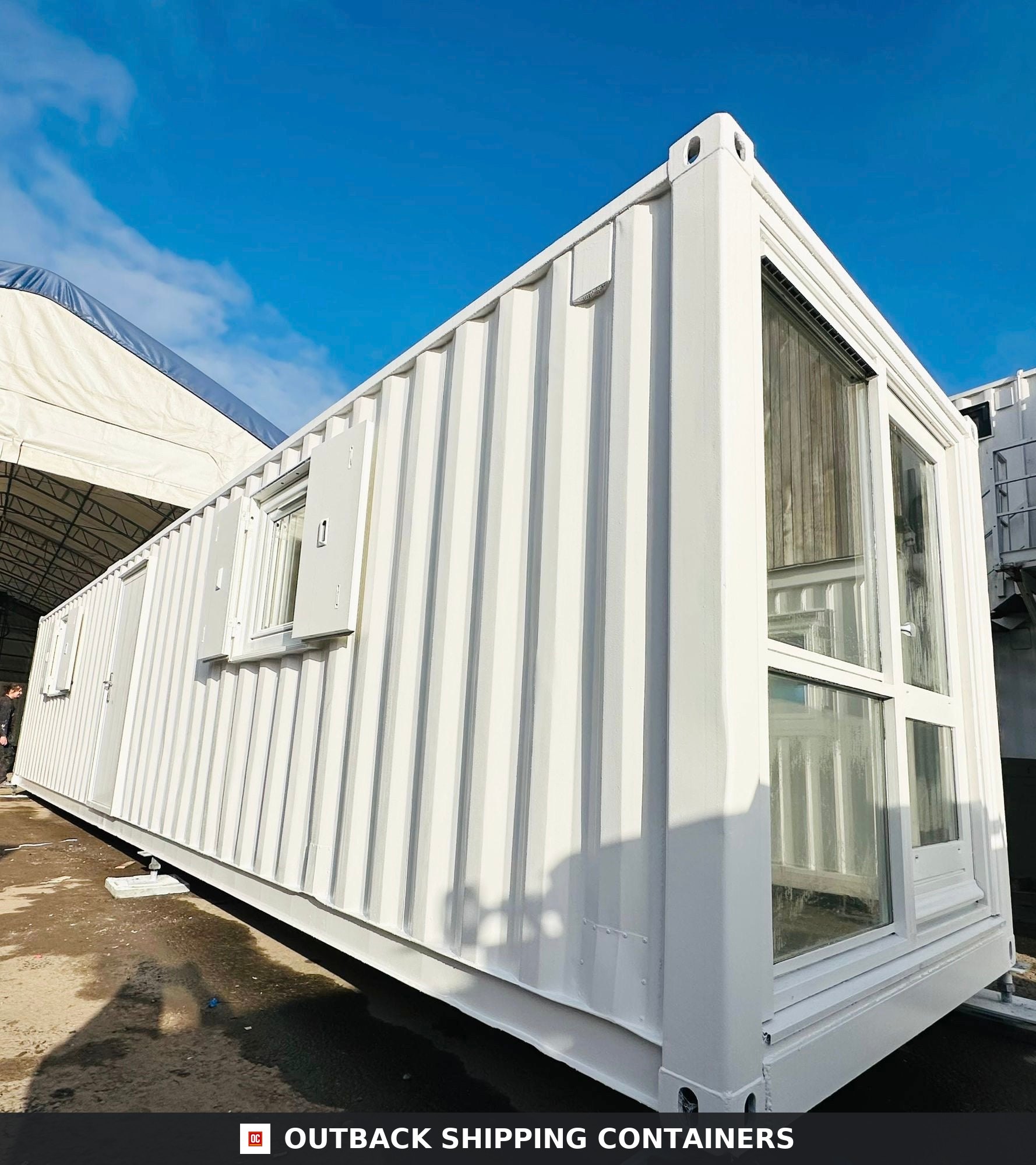 40ft white converted shipping container office with vertical corrugated steel walls and a large front glass window