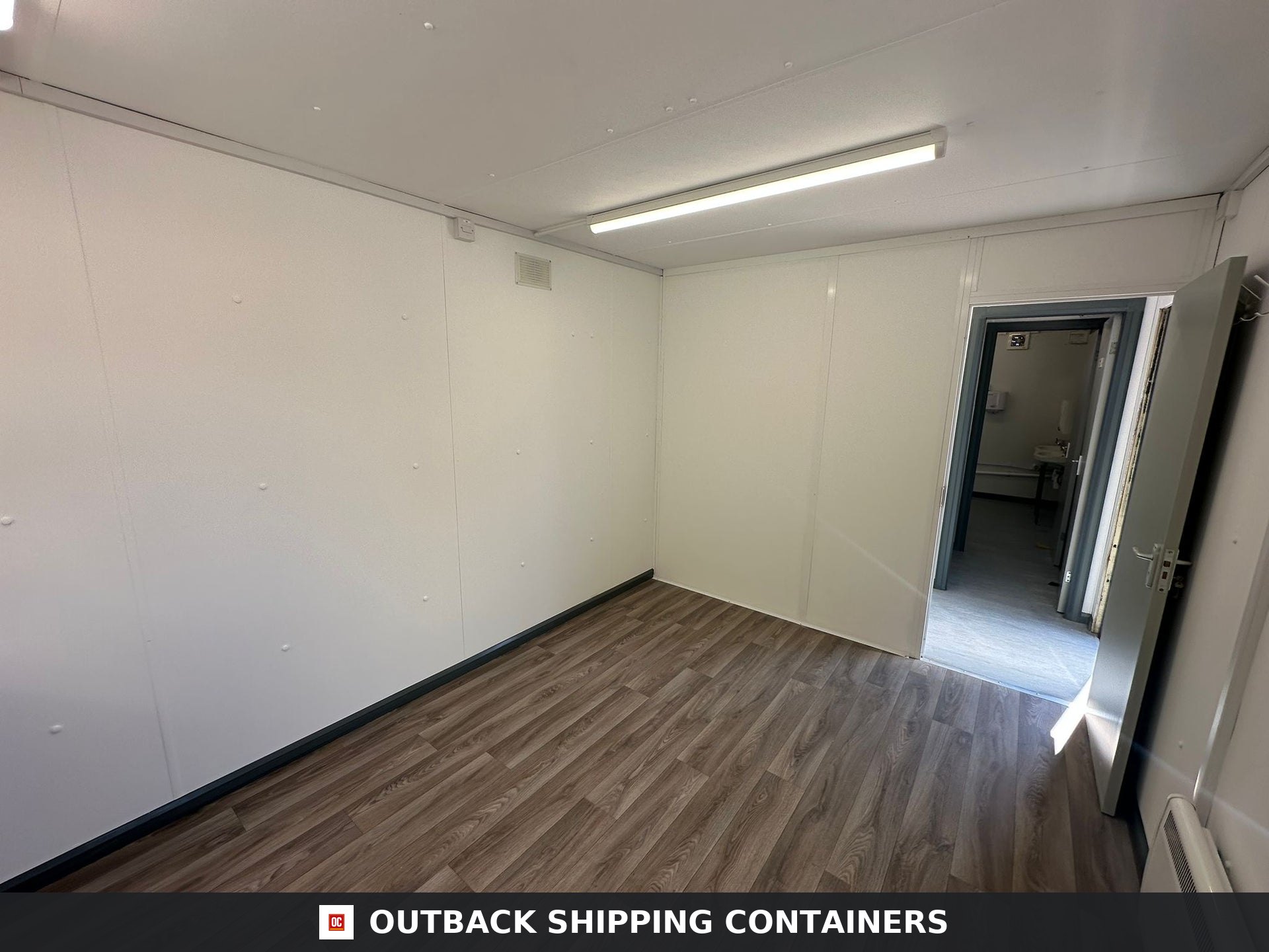 32 x 10Ft 32x10FT for Sale — Interior Detail | Outback Shipping Containers Interior view of a refurbished 32x10 shipping container office with wood laminate flooring and white walls