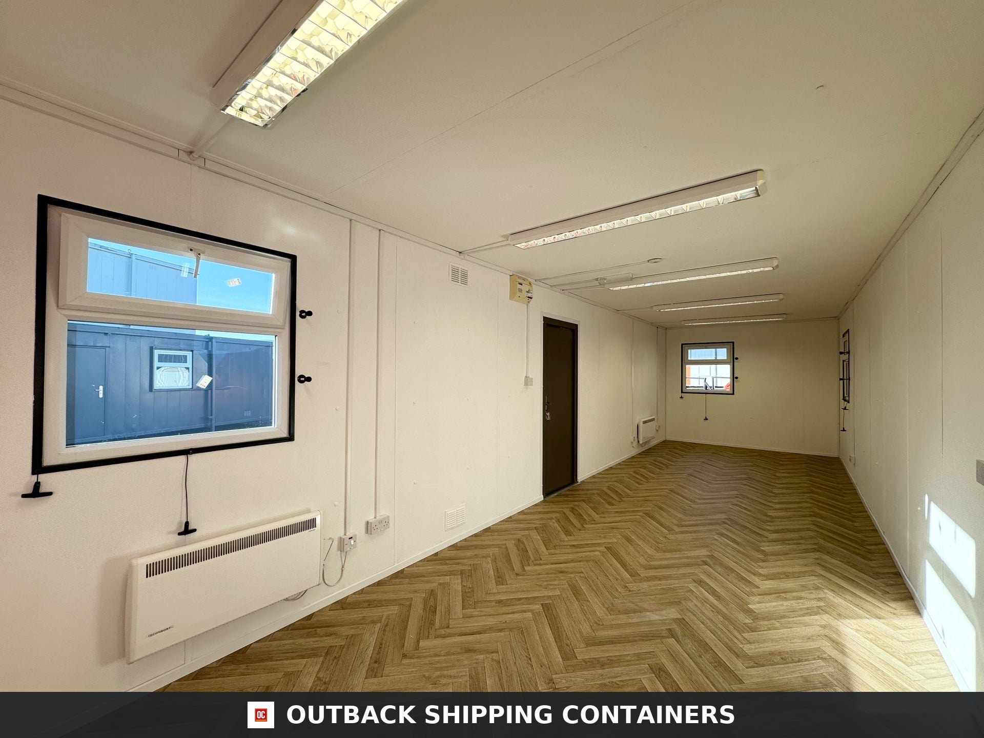 32ft Cabin for Sale — Door and Entry Detail | Outback Shipping Containers 2 Refurbished 32ft anti-vandal cabin in charcoal gray with a side window and steel support legs on a dirt lot