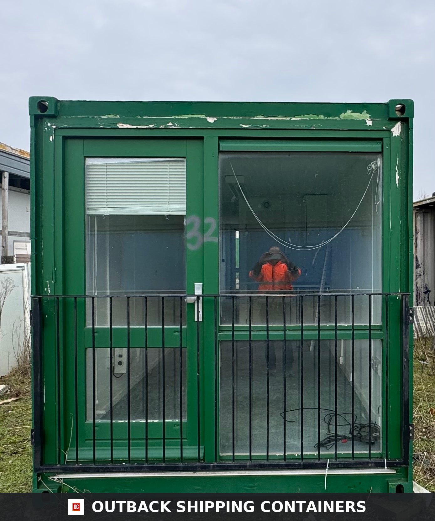 Converted Shipping Container 40 Ft 40FT — Door and Entry Detail | Outback Shipping Containers Green 40ft container office exterior showing glass door and large window with safety bars