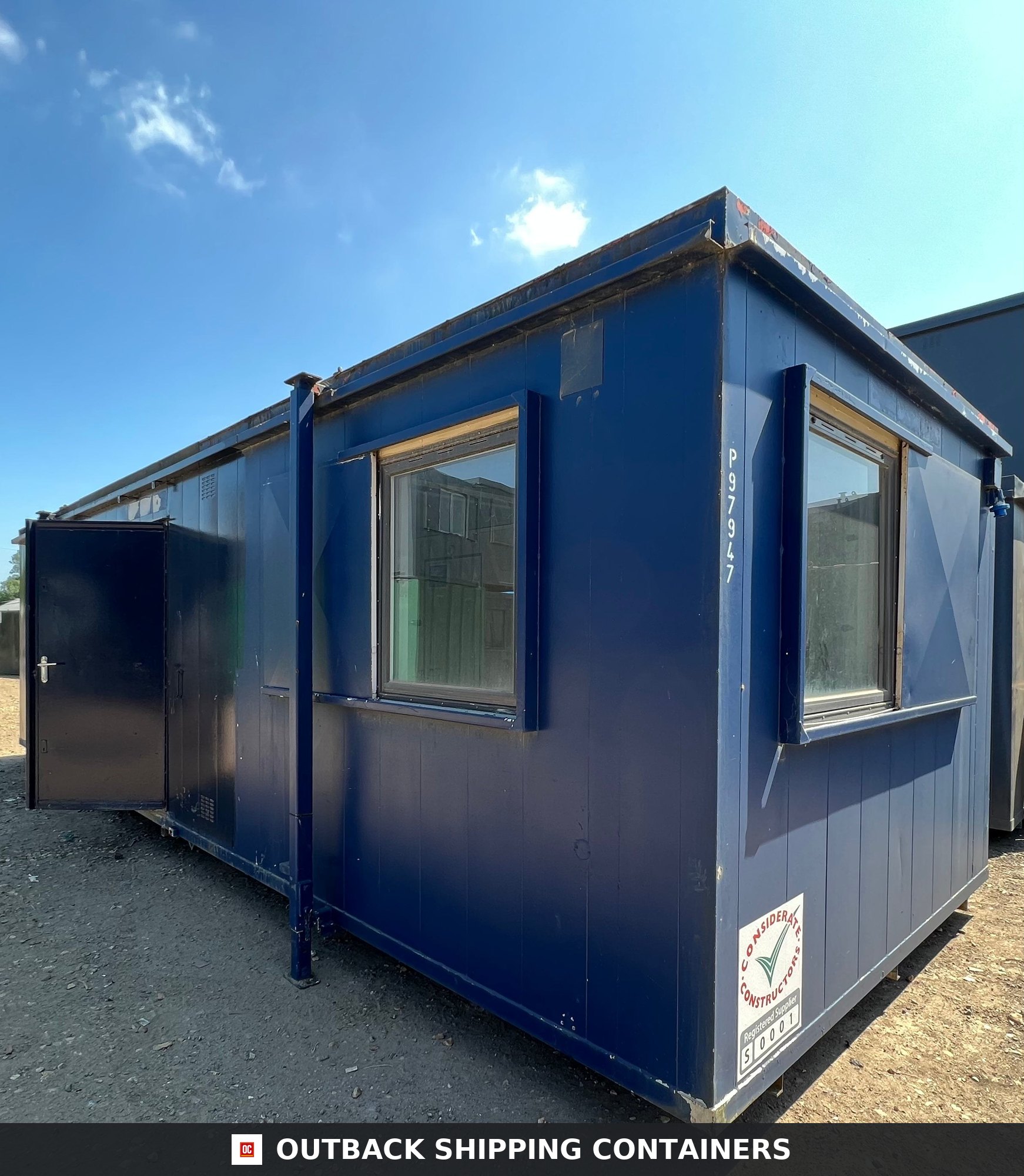 24x9 ft 24X9FT for Sale — Window and Shutter Detail | Outback Shipping Containers 24x9 ft blue anti-vandal portable cabin with wide windows and an open metal door on a gravel site under blue sky