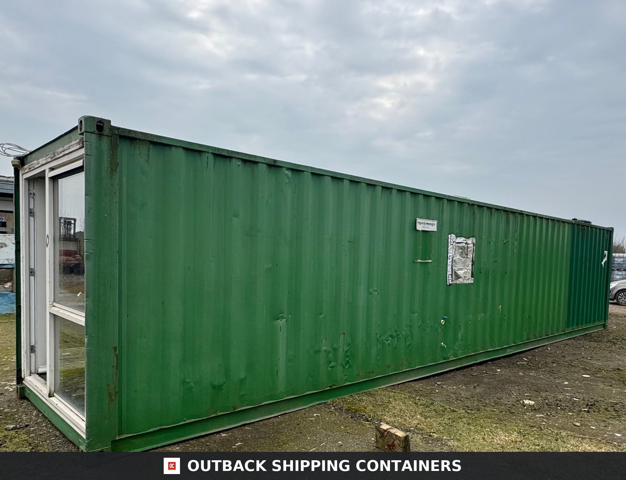 40 Ft Converted Shipping Container 40FT for Sale — Window and Shutter Detail Exterior side view of a 40ft green converted shipping container office with a large glass door and metal siding