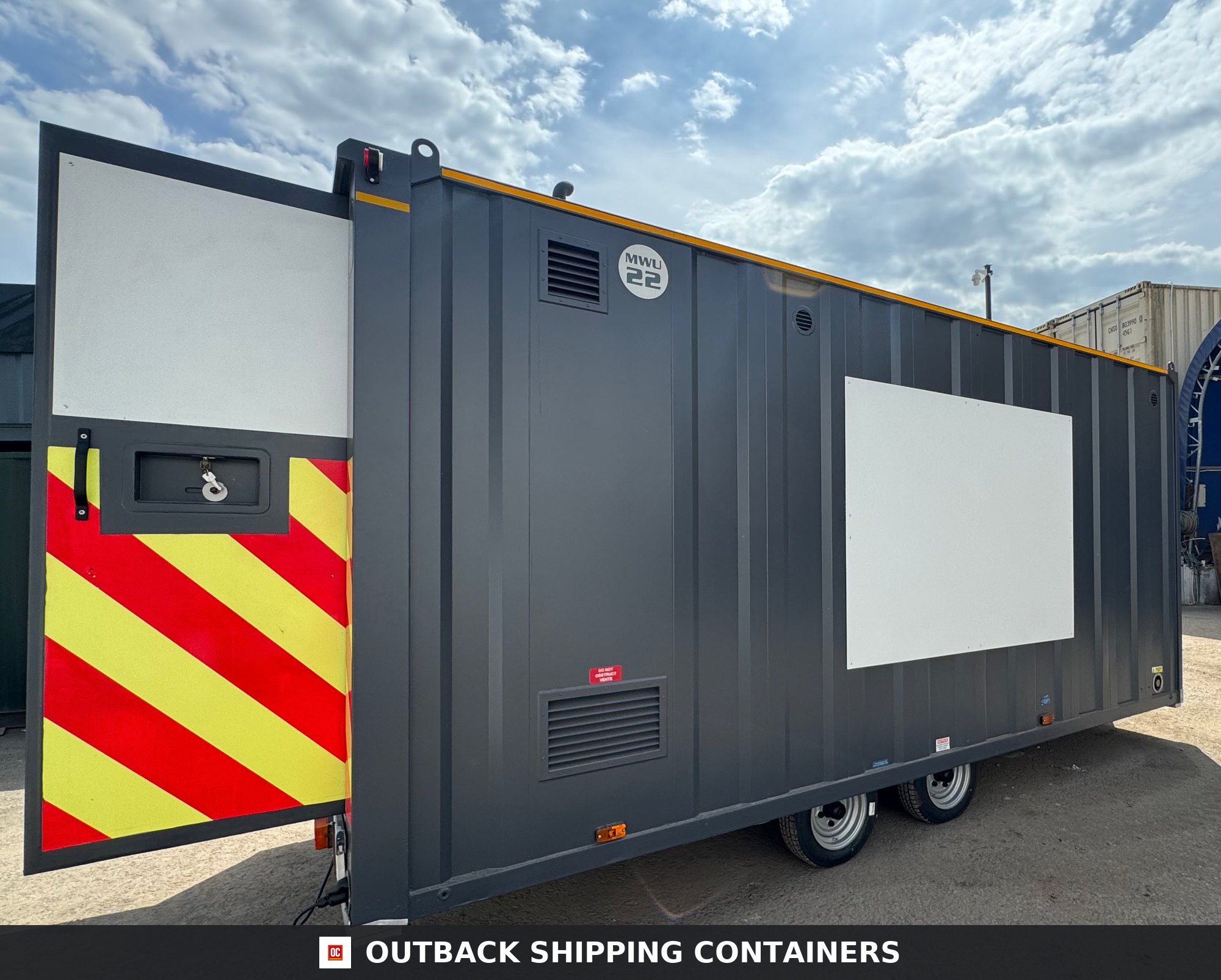 Groundhog Towable Mobile Welfare | 16 Ft | 2017 |Twin Axle — Corner Casting and Frame Detail Groundhog towable mobile welfare unit with an open rear door featuring yellow and red high-visibility safety chevrons