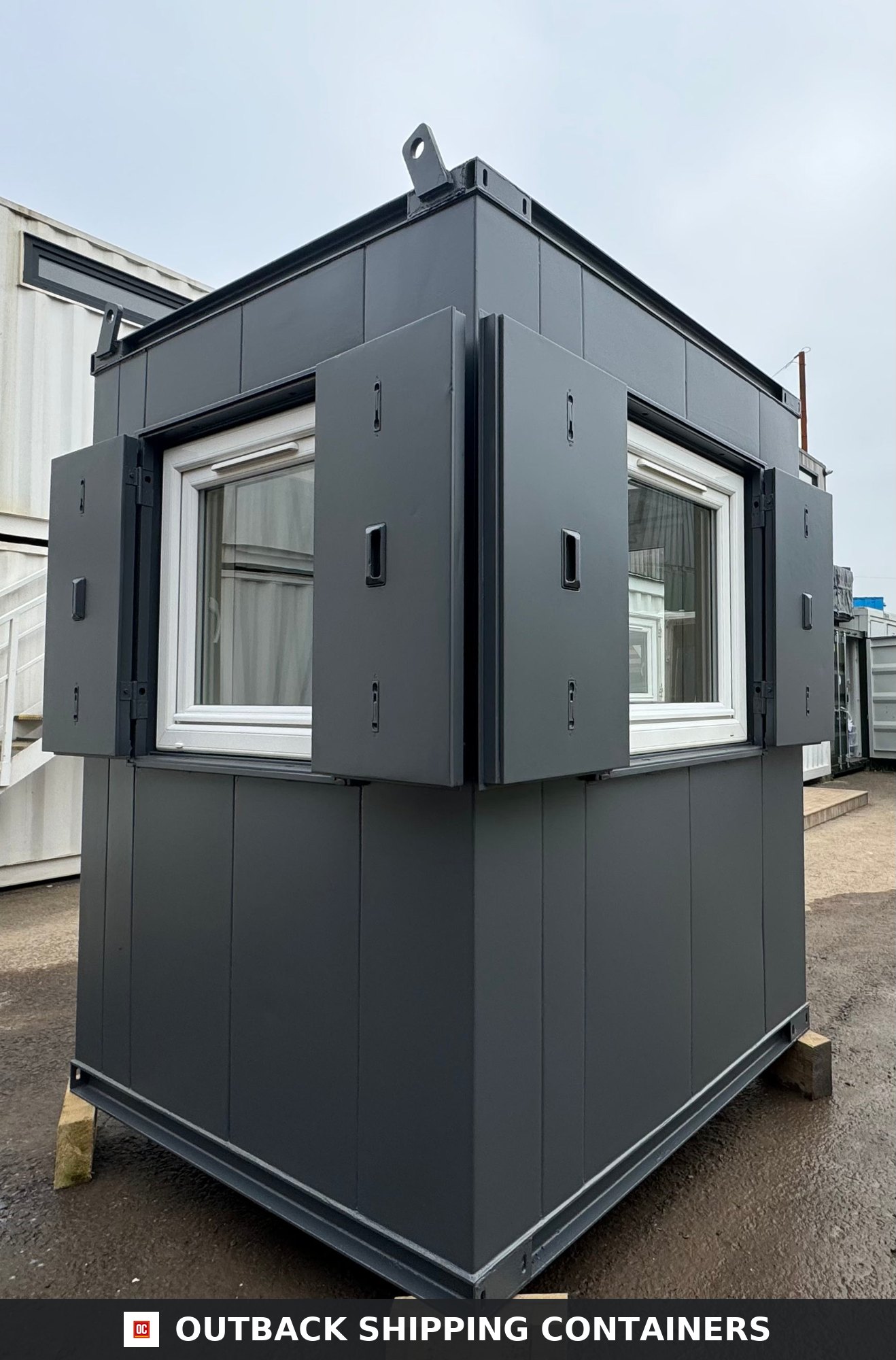 6x6 ft 6x6FT for Sale — Interior Detail | Outback Shipping Containers Full corner view of a refurbished 6x6 ft dark gray anti-vandal gate house with open steel window shutters