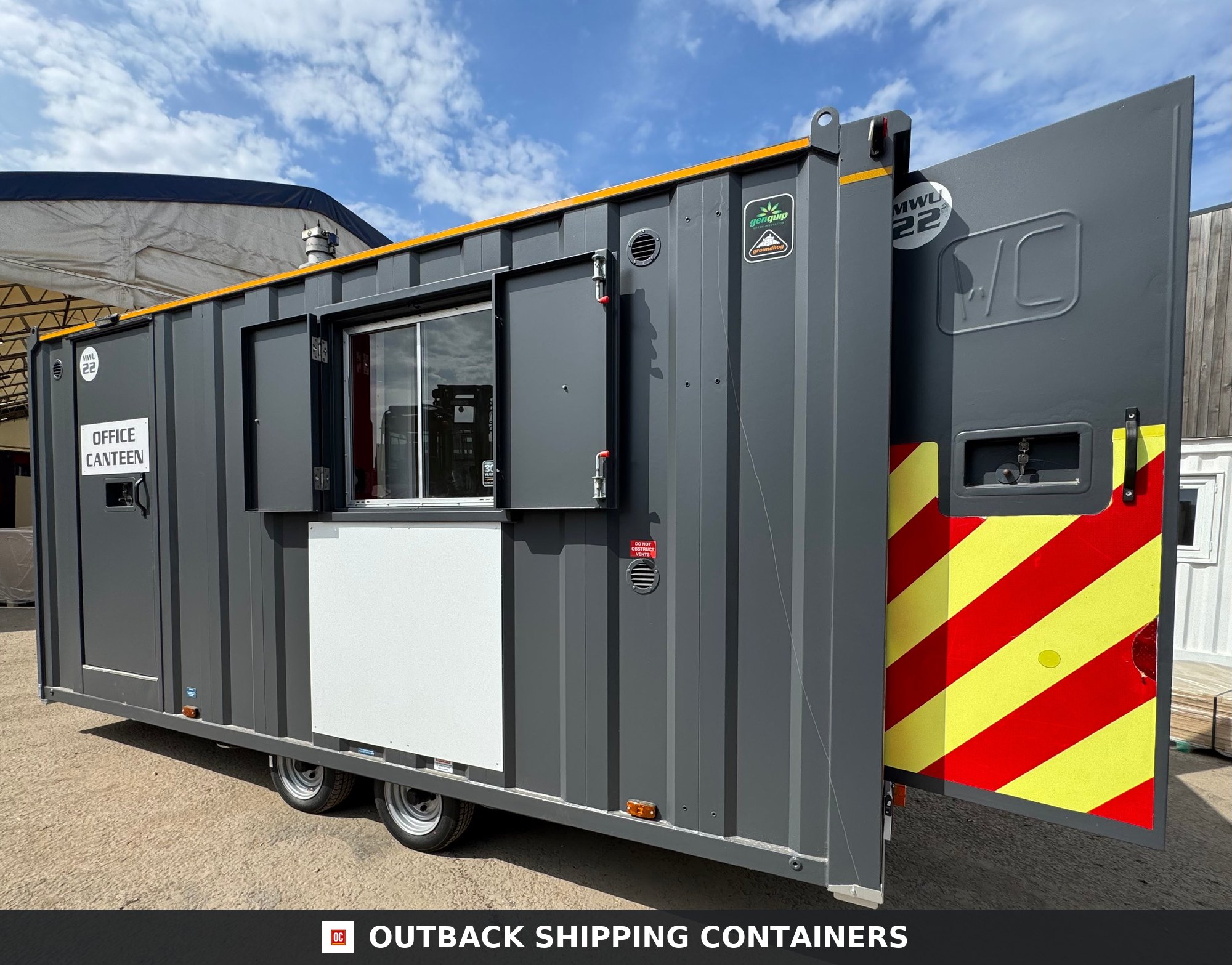 Groundhog Towable Mobile Welfare | 16 Ft | 2017 |Twin Axle | GPO500 — Rear Exterior View Side profile of a dark grey Groundhog towable mobile welfare unit with open window shutters and yellow safety stripes
