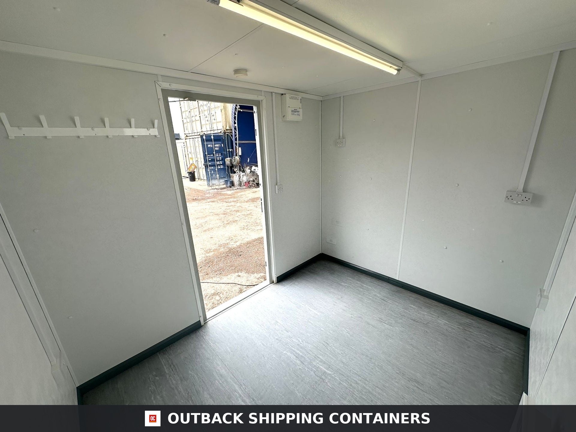 10x8 ft 10X8FT for Sale — Three-Quarter Angle View | Outback Shipping Containers Interior of 10x8 portable garden office with white walls, grey flooring, and overhead lighting
