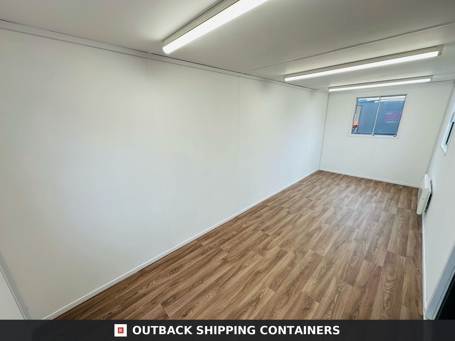 21x8ft for Sale — Rear Exterior View | Outback Shipping Containers 2 3 4 5 Interior view of a 21x8ft refurbished portable office container featuring wood vinyl flooring and a black steel door