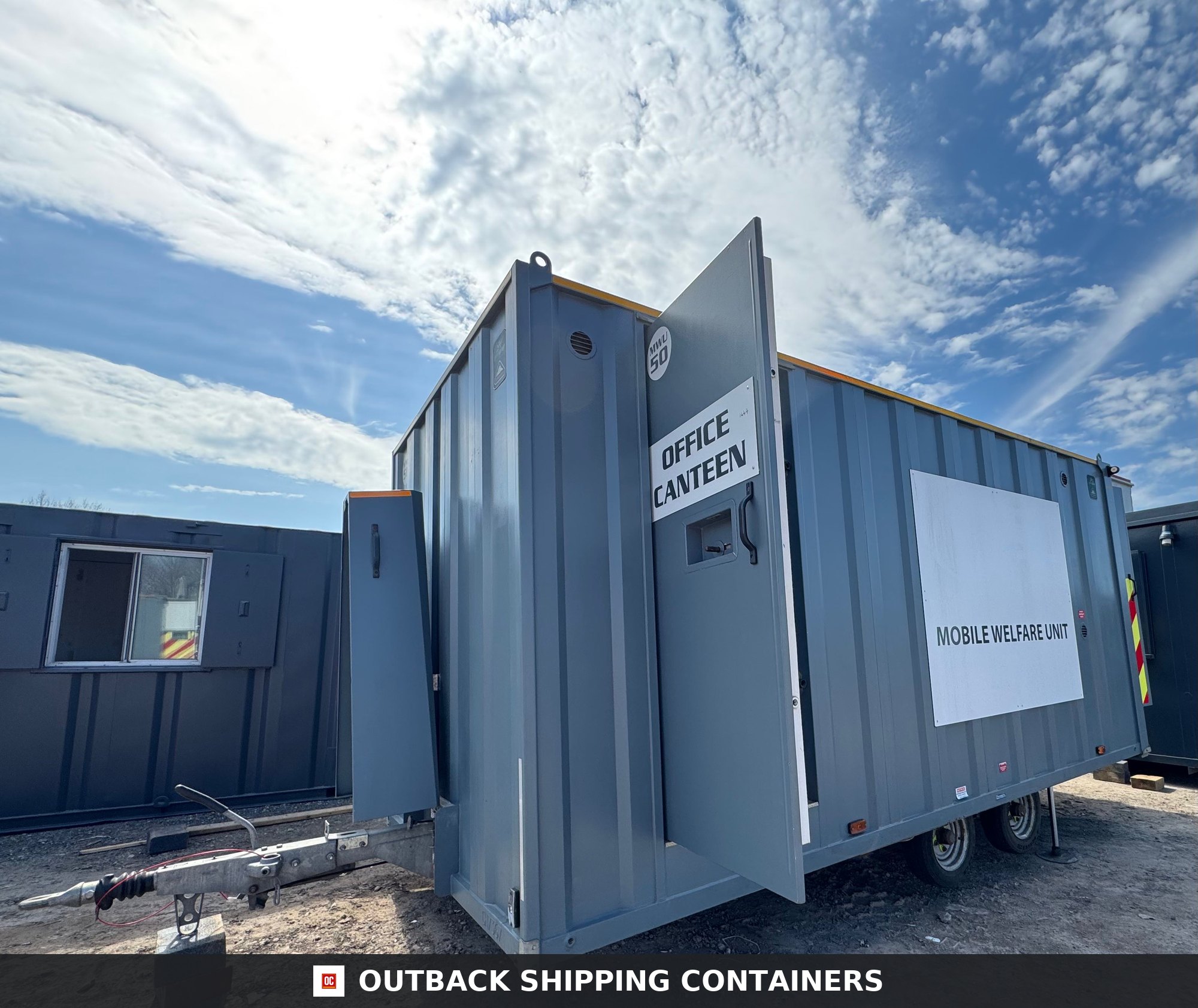 Groundhog Towable Mobile Welfare | 2019 Twin Axle 16ft Welfare | GPO500 — Interior Detail Side profile of a grey Groundhog towable mobile welfare unit with the office canteen door open under a blue sky