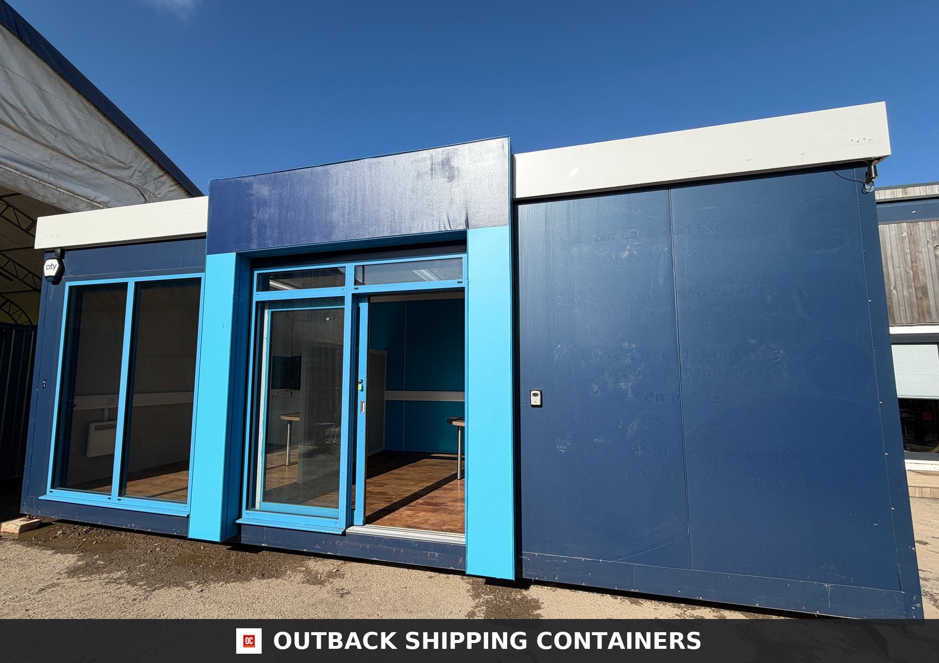 26x12ft for Sale — Roof and Structural Detail | Outback Shipping Containers Interior view of a portable marketing suite featuring office partitions, wood flooring, and blue window shutters