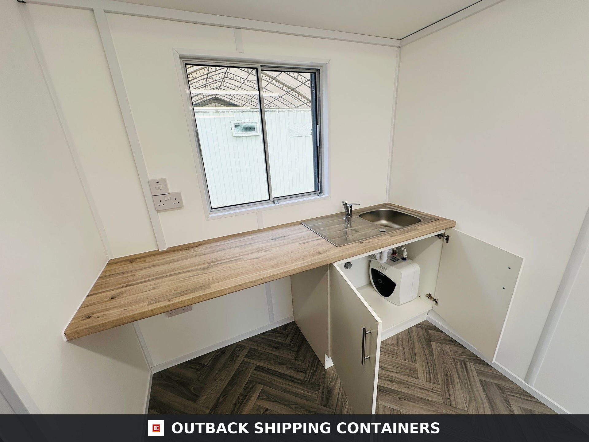 21x8ft for Sale — Interior View | Outback Shipping Containers Refurbished 21x8 anti vandal container office interior featuring wood herringbone flooring and white walls