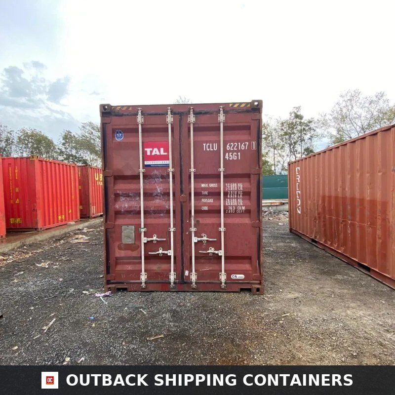 Rear view of a red 40ft used shipping container with double doors closed in an outdoor storage yard