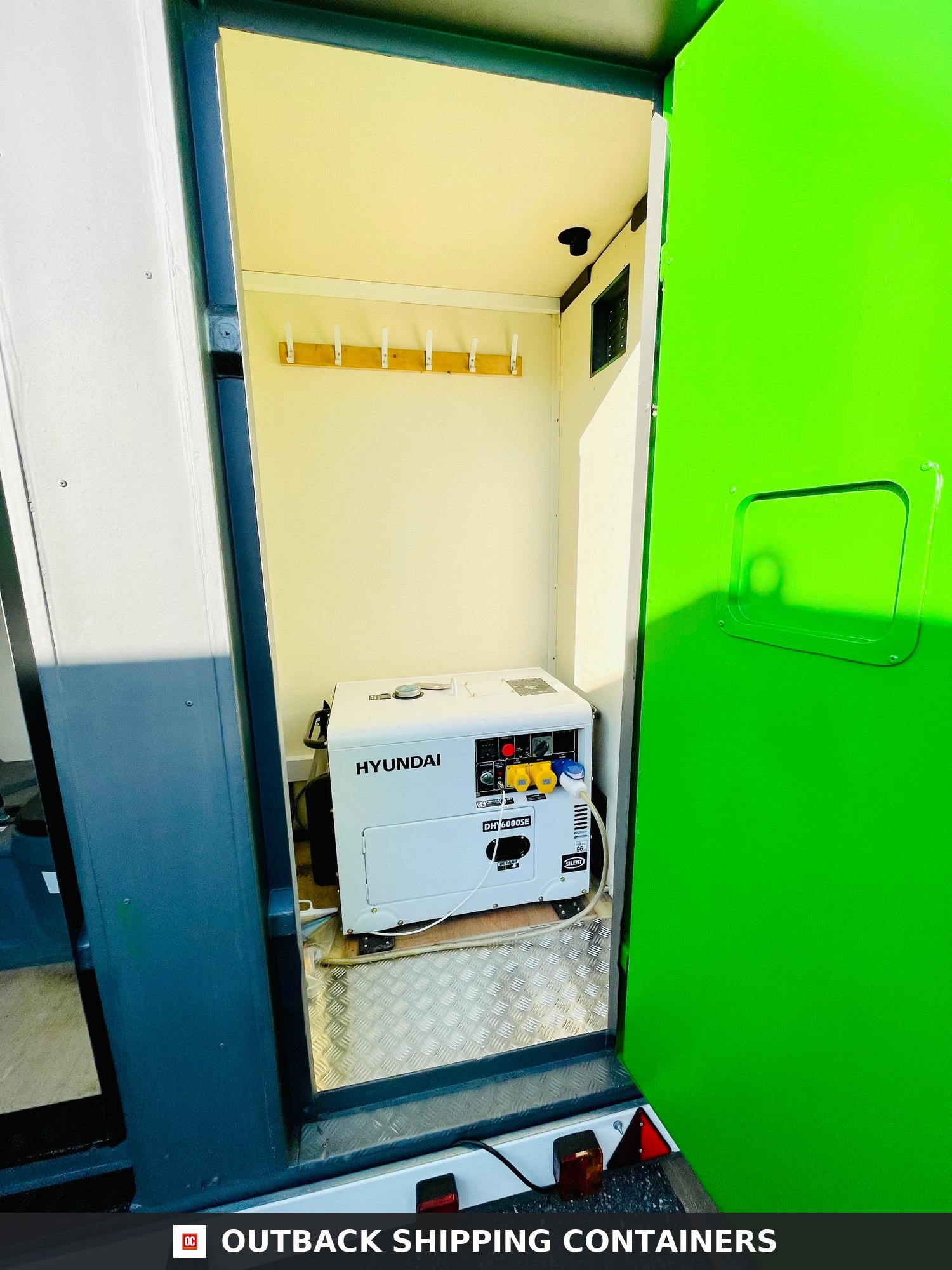 Towable Groundhog Mobile Welfare |Towable Canteen, Office, WC, Drying Room — Interior View Interior view of a mobile welfare unit showing a Hyundai DHY6000SE diesel generator in a dedicated storage bay