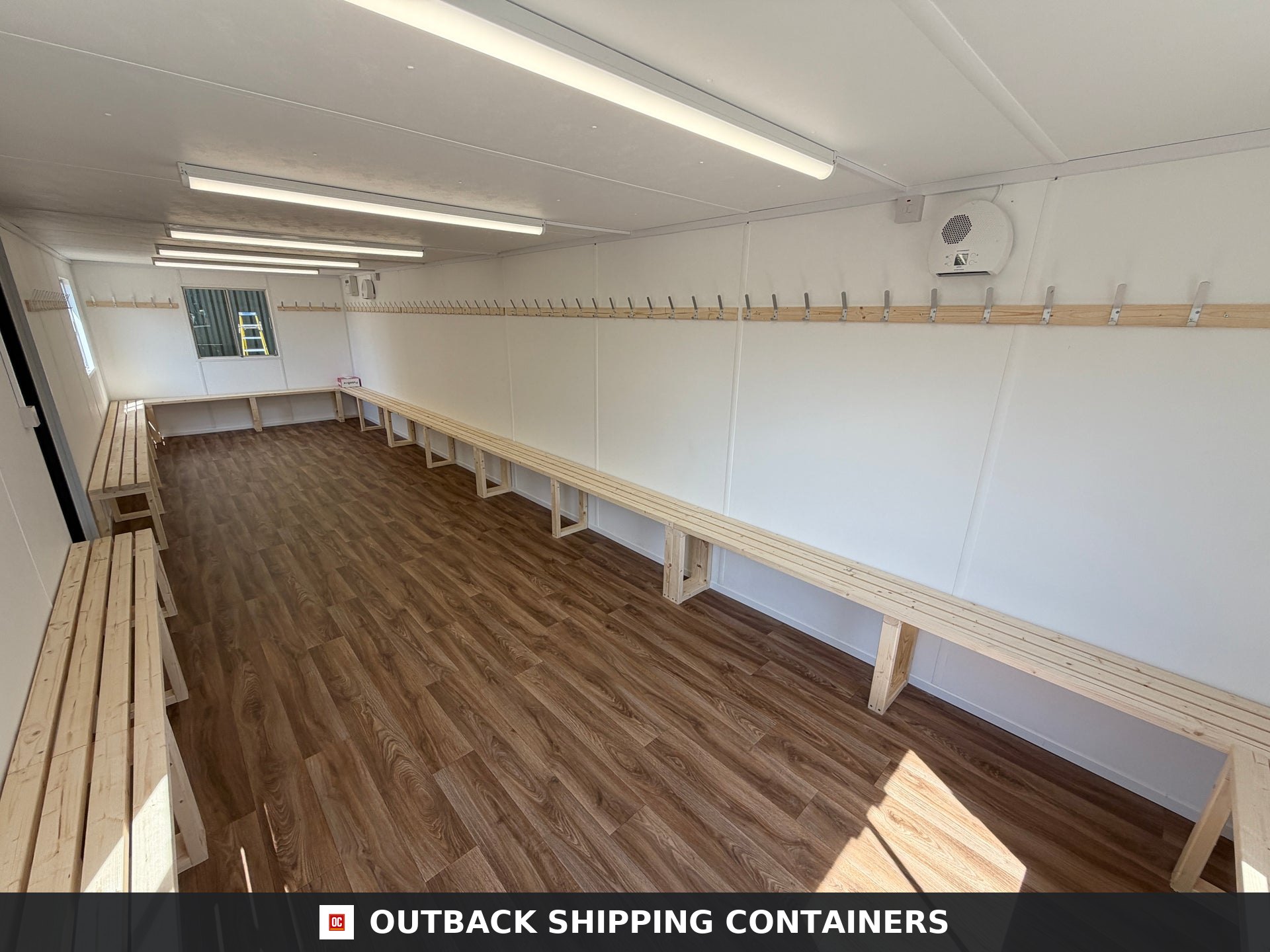 32x10ft Cabin for Sale — Rear Exterior View | Outback Shipping Containers 2 3 4 Interior of 32x10 portable shipping container cabin with wooden benches slatted walls and coat hooks