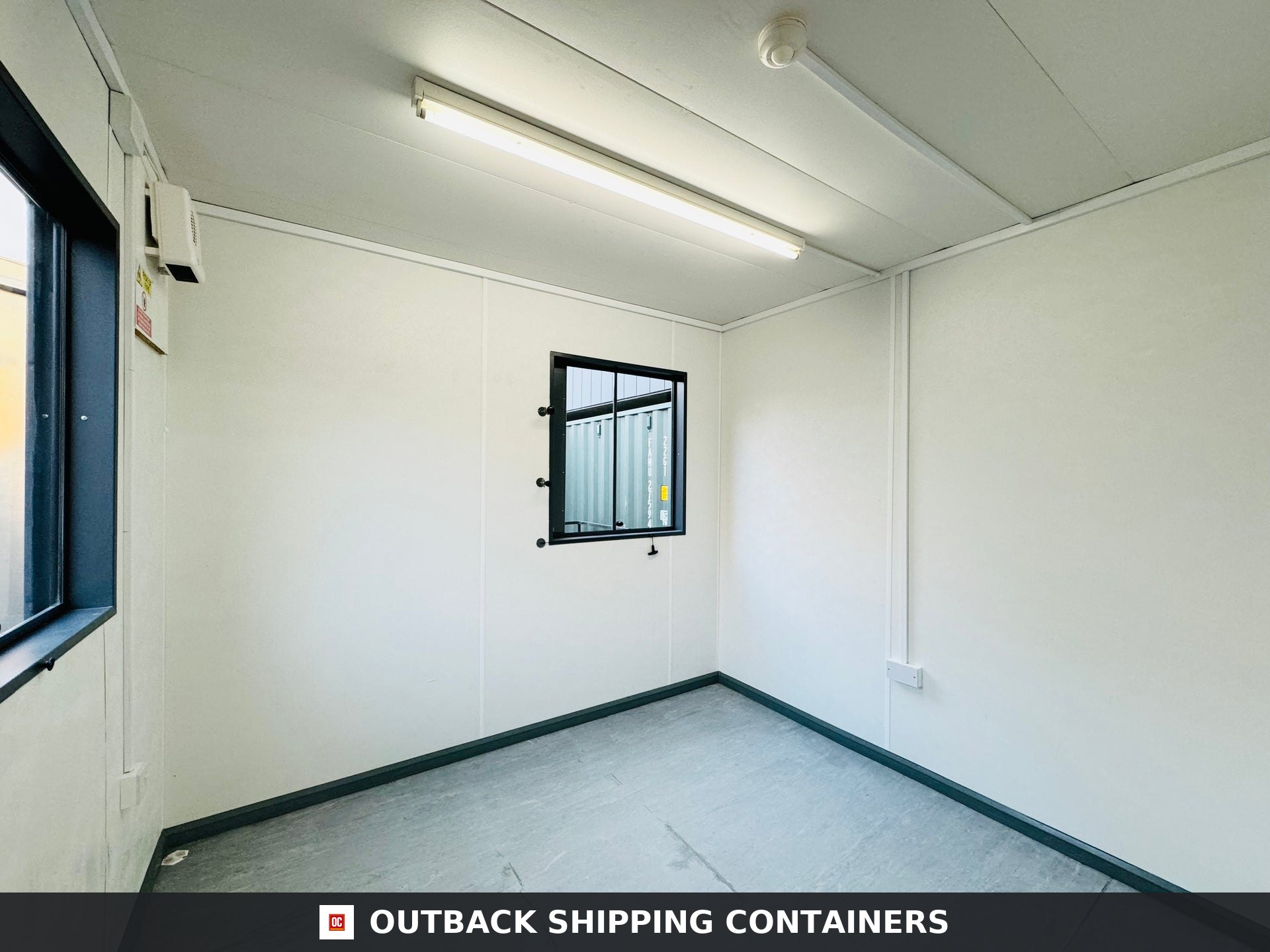 32x10ft for Sale — Rear Exterior View | Outback Shipping Containers Interior view of a refurbished 32x10ft portable unit showing white walls, vinyl floor, overhead light, and windows
