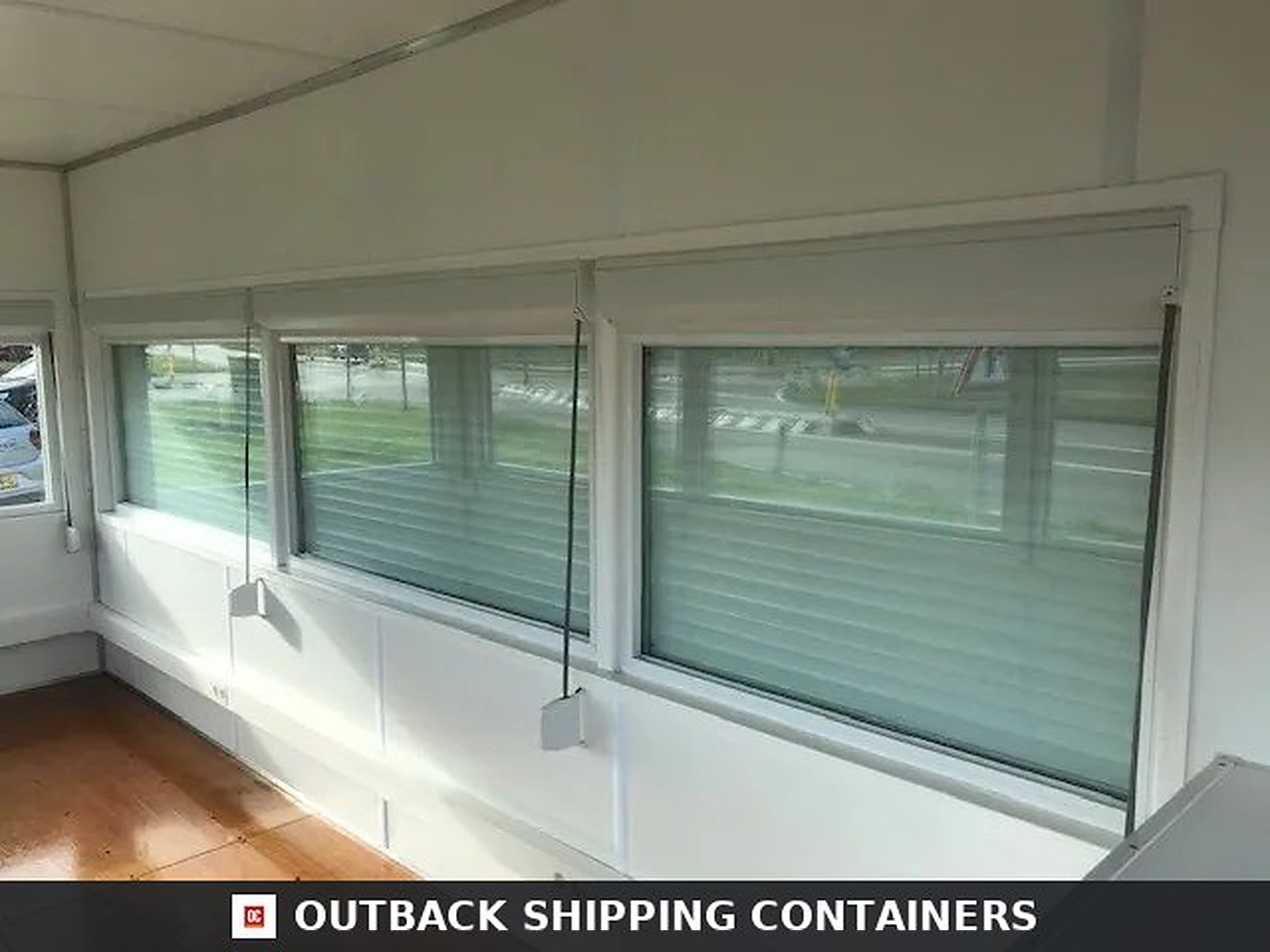 Interior view of three large fixed glazing windows with integrated blinds in a 20ft high cube observation container