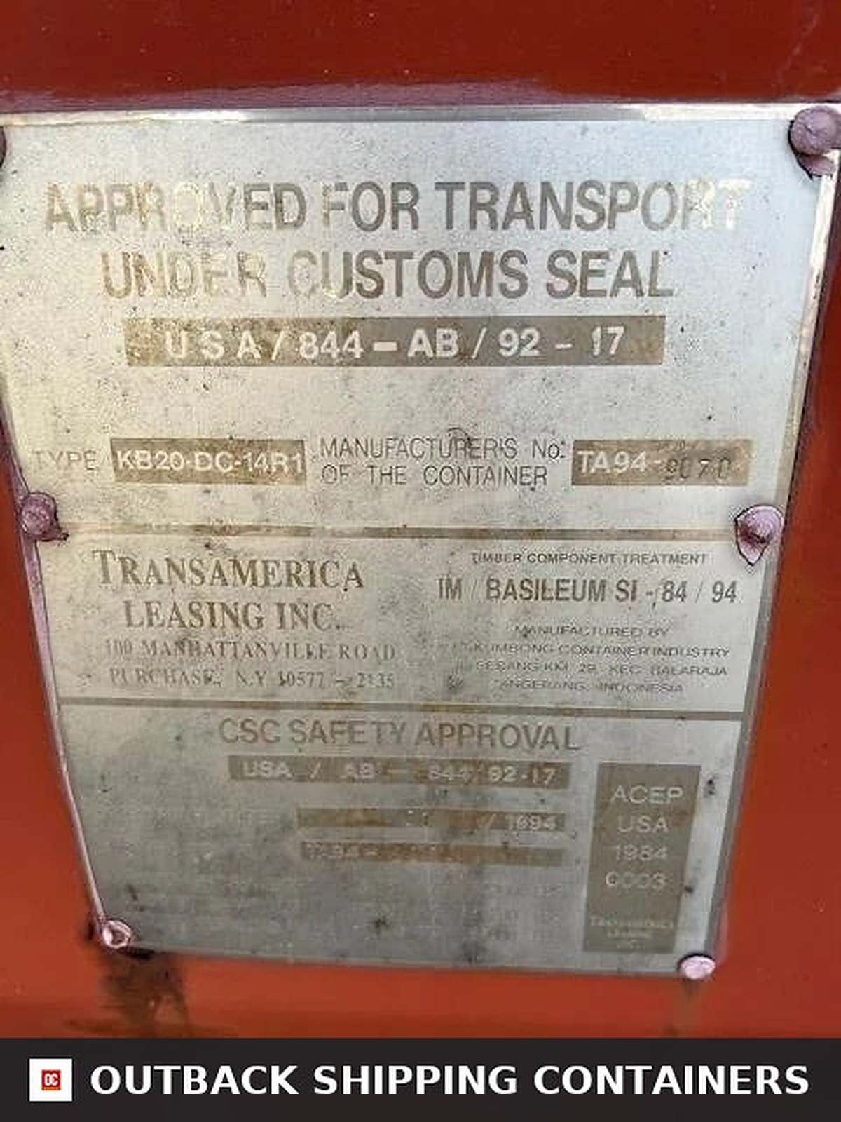 Metal CSC safety approval plate on a used red 20ft shipping container showing manufacturer and transport specifications