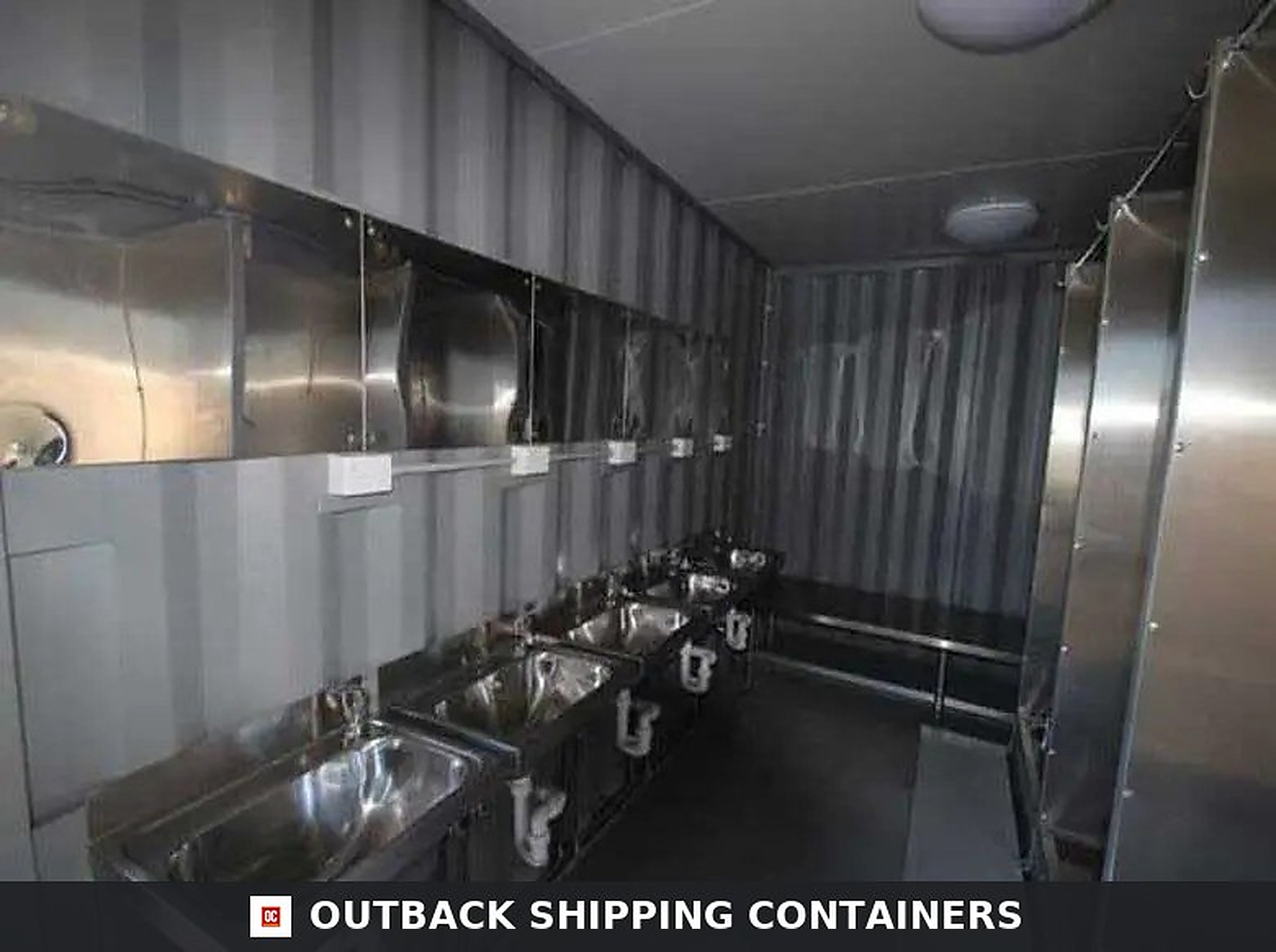 Ablution blocks portable toilet unit interior showing stainless steel sinks mirrors and industrial lighting