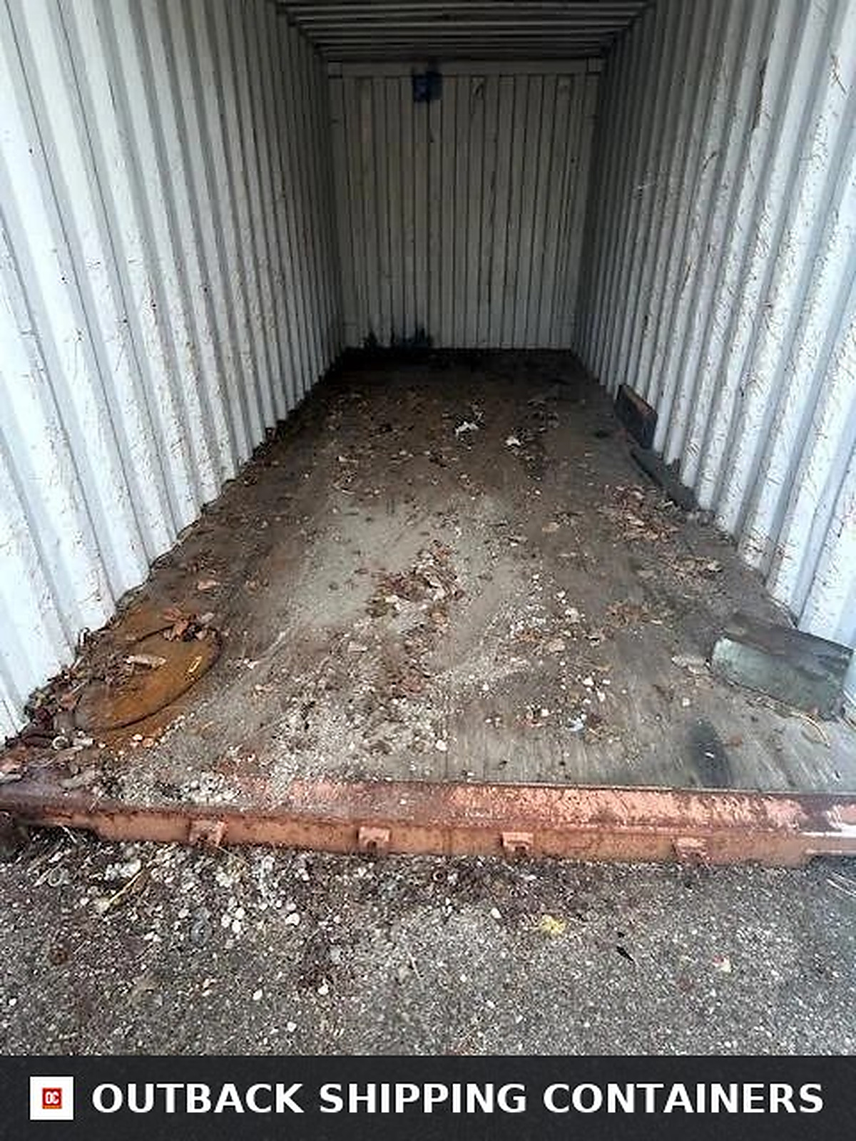 Interior view of a used 20ft shipping container with steel walls and wooden flooring containing debris