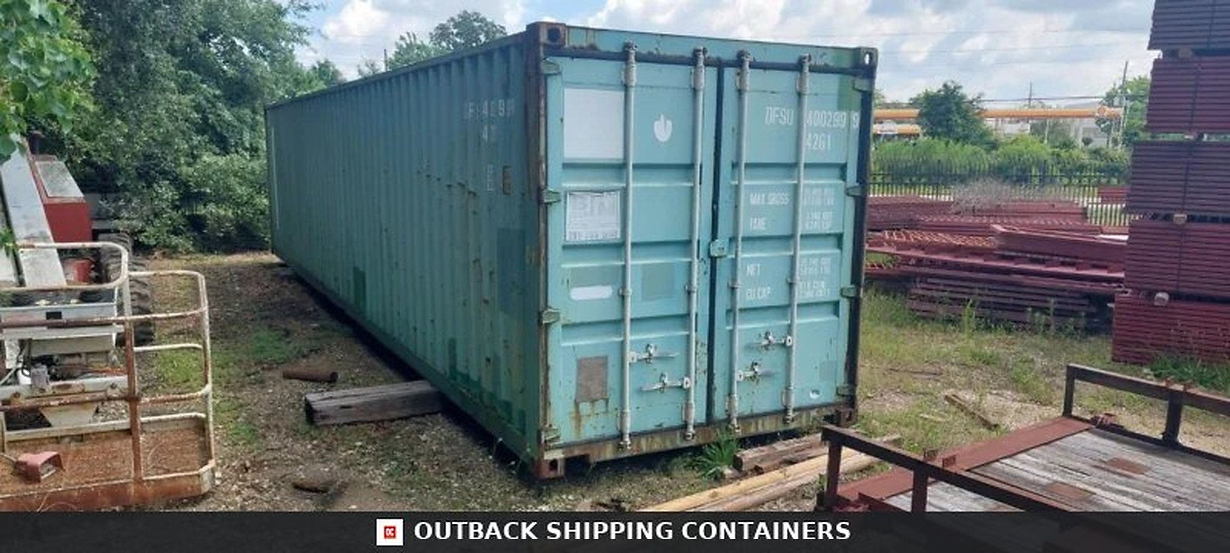 Watertight 40ft shipping container in light blue with steel locking bars and cargo doors in a gravel lot