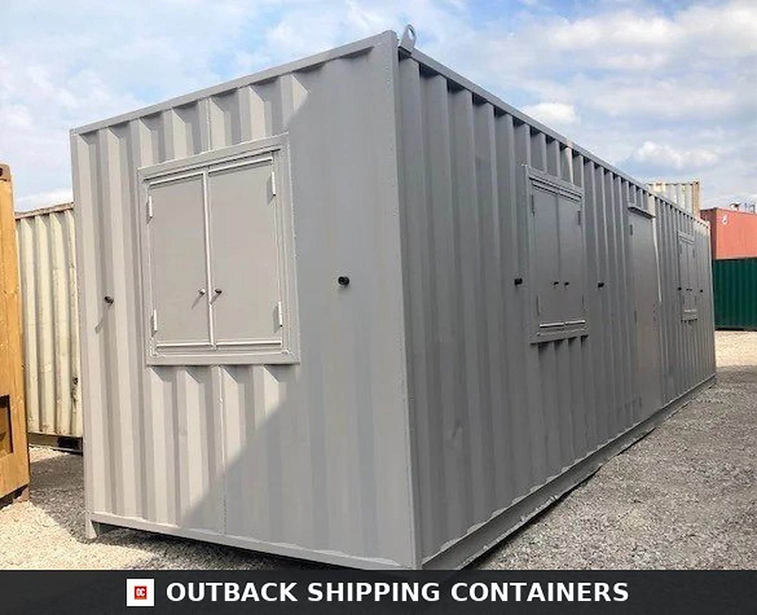 Gray 30ft ModiBox office container with steel security window shutters and a matching metal personnel door
