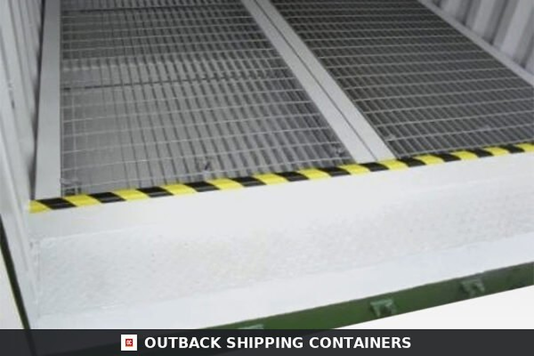 20Ft X 8Ft Open Side Bunded Open Mesh Floor Store for Sale — Three-Quarter Angle View Interior view of a 20ft bunded storage container showing silver galvanized open mesh floors and a yellow safety tape edge