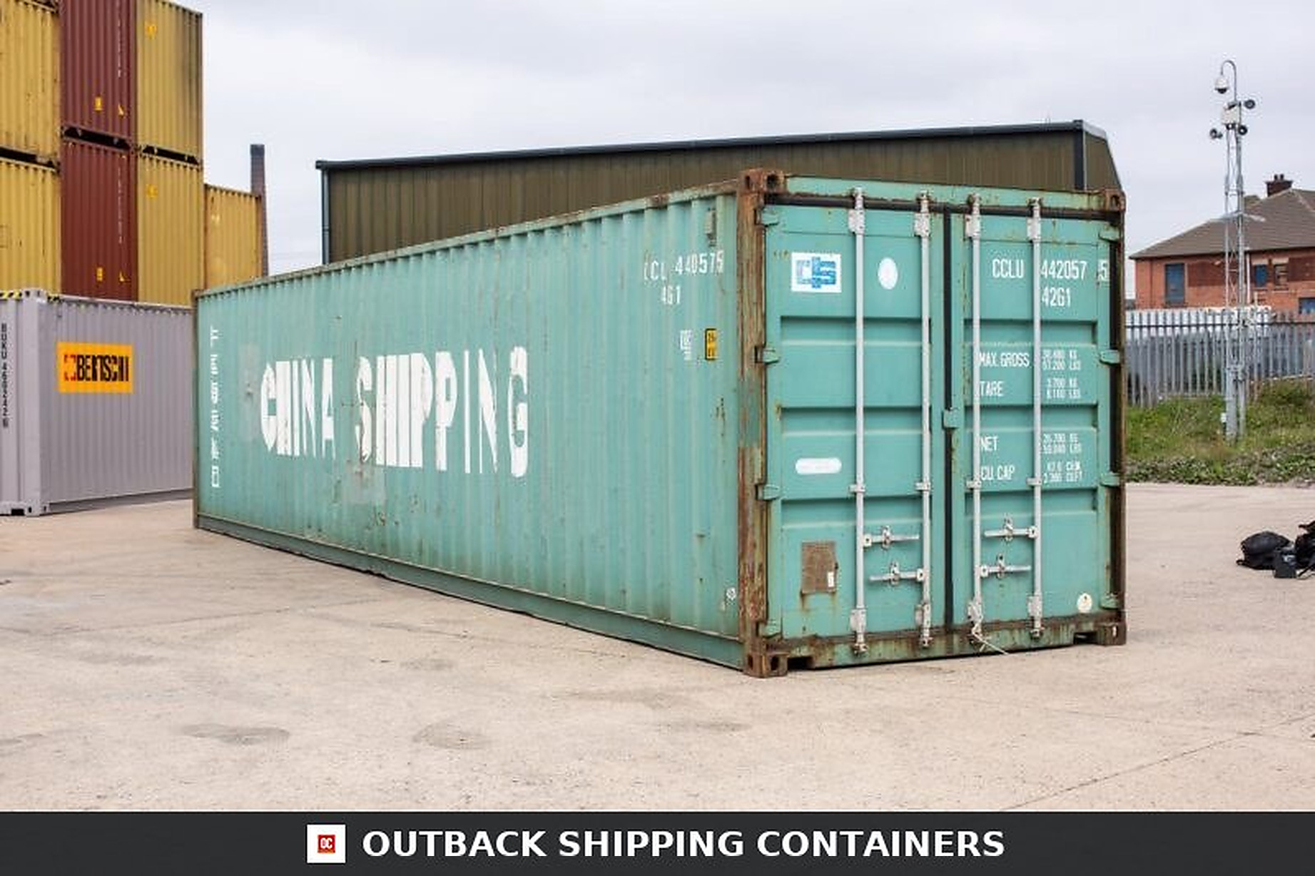 Refurbished green 40ft shipping container showing side panel and closed rear doors in a depot